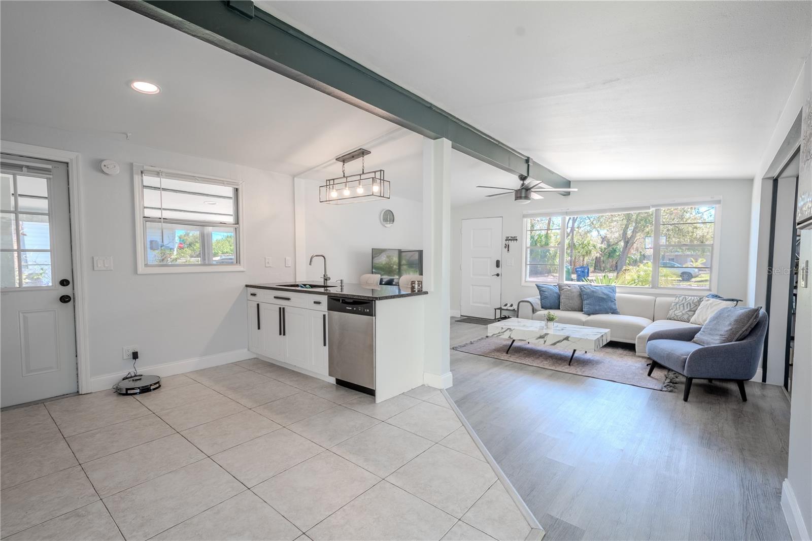 The living room and kitchen, seamlessly connect, both batherd in neutral tones.