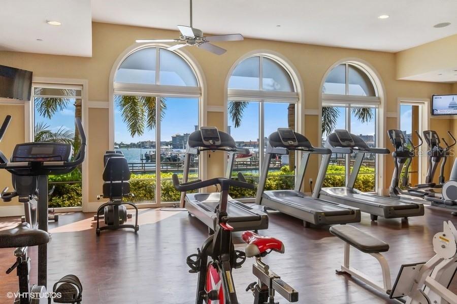 Fitness Center has high, high ceilings and windows viewing the Belle Harbor Marina and Mandalay Channel.