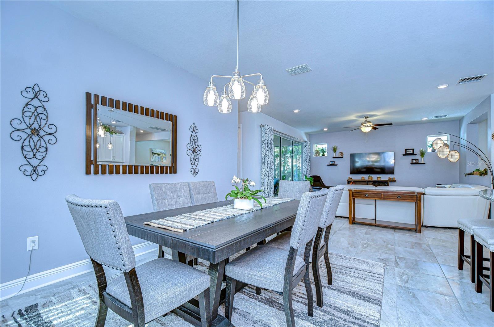 Dive into elegance with this open-concept living and dining area, featuring chic lighting, plush seating, and serene tones