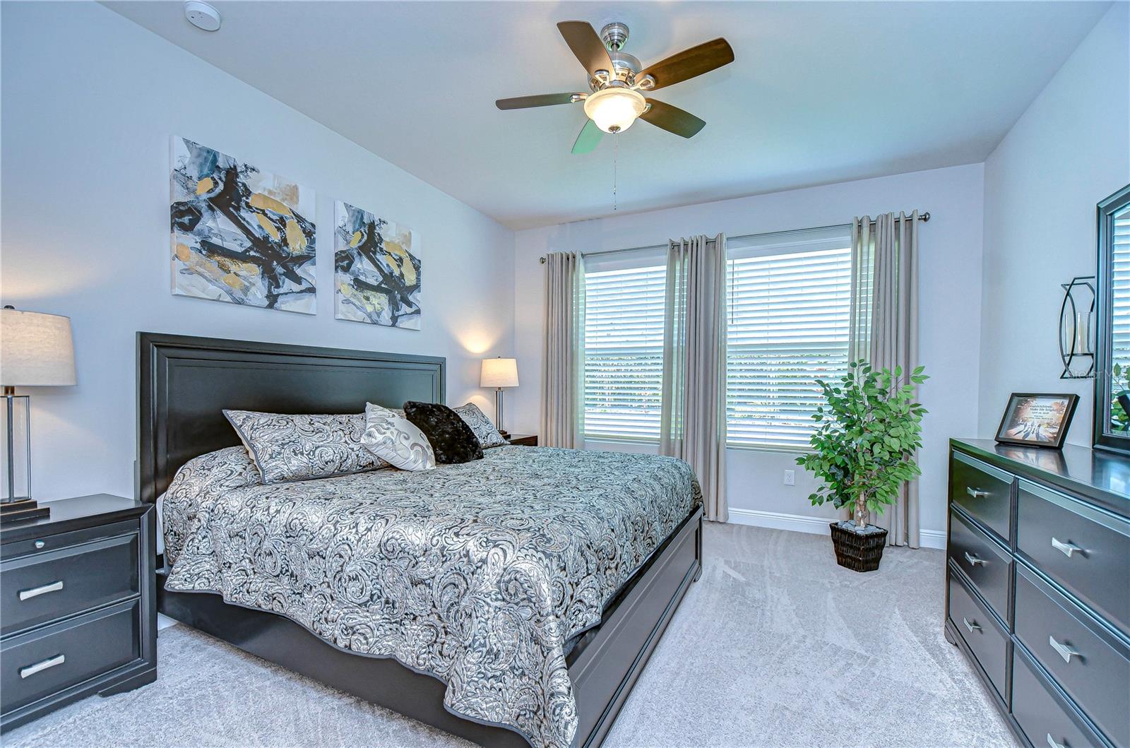 Retreat to this serene primary bedroom, where sunlight dances through the windows and modern elegance meets comfort.