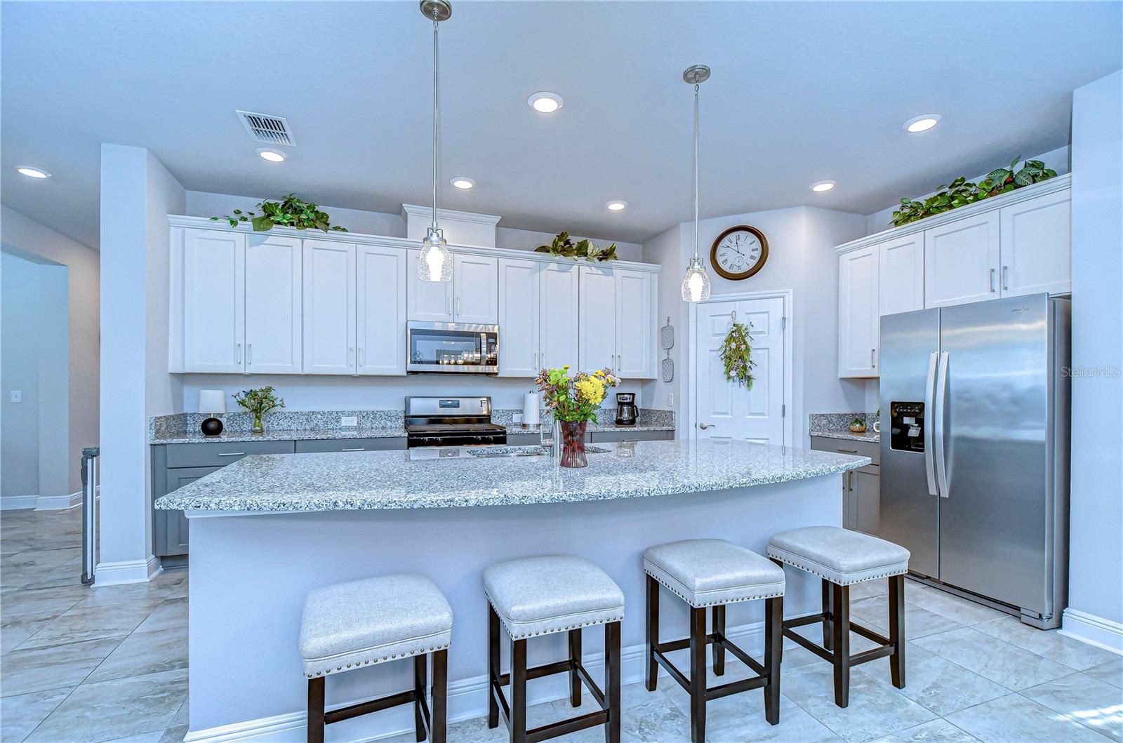 This elegant kitchen features sleek granite countertops, modern stainless steel appliances, and ample storage in