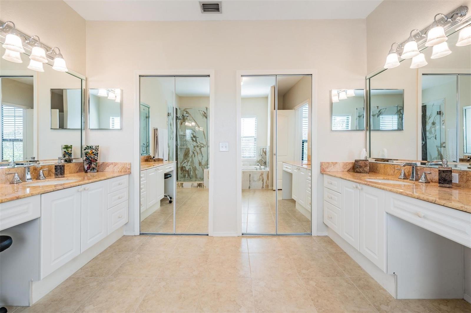 Separate vanities, each with dedicated makeup vanity spots and large walk-in closet with dual entry access