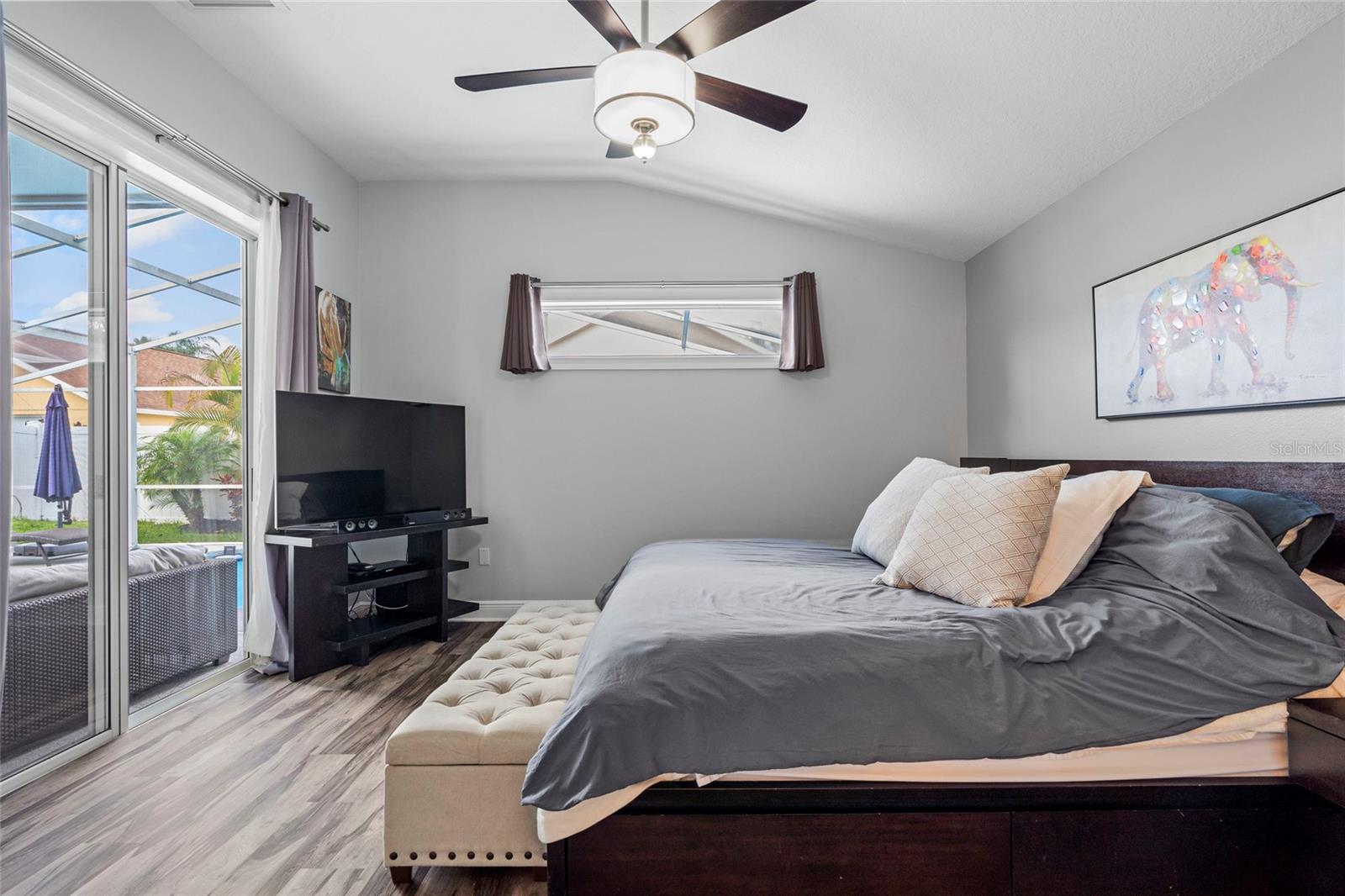 Primary bedroom over looking pool and covered patio.