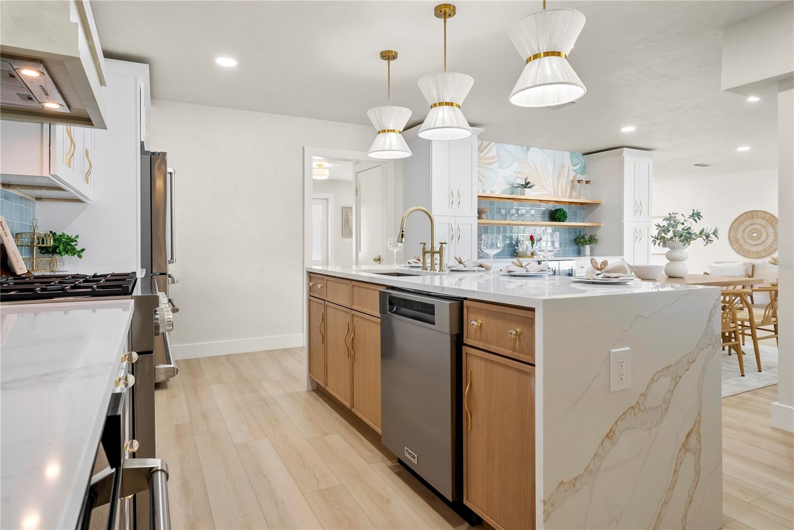 View of custom waterfall island with detail of the dishwasher and sink located in the center of the island