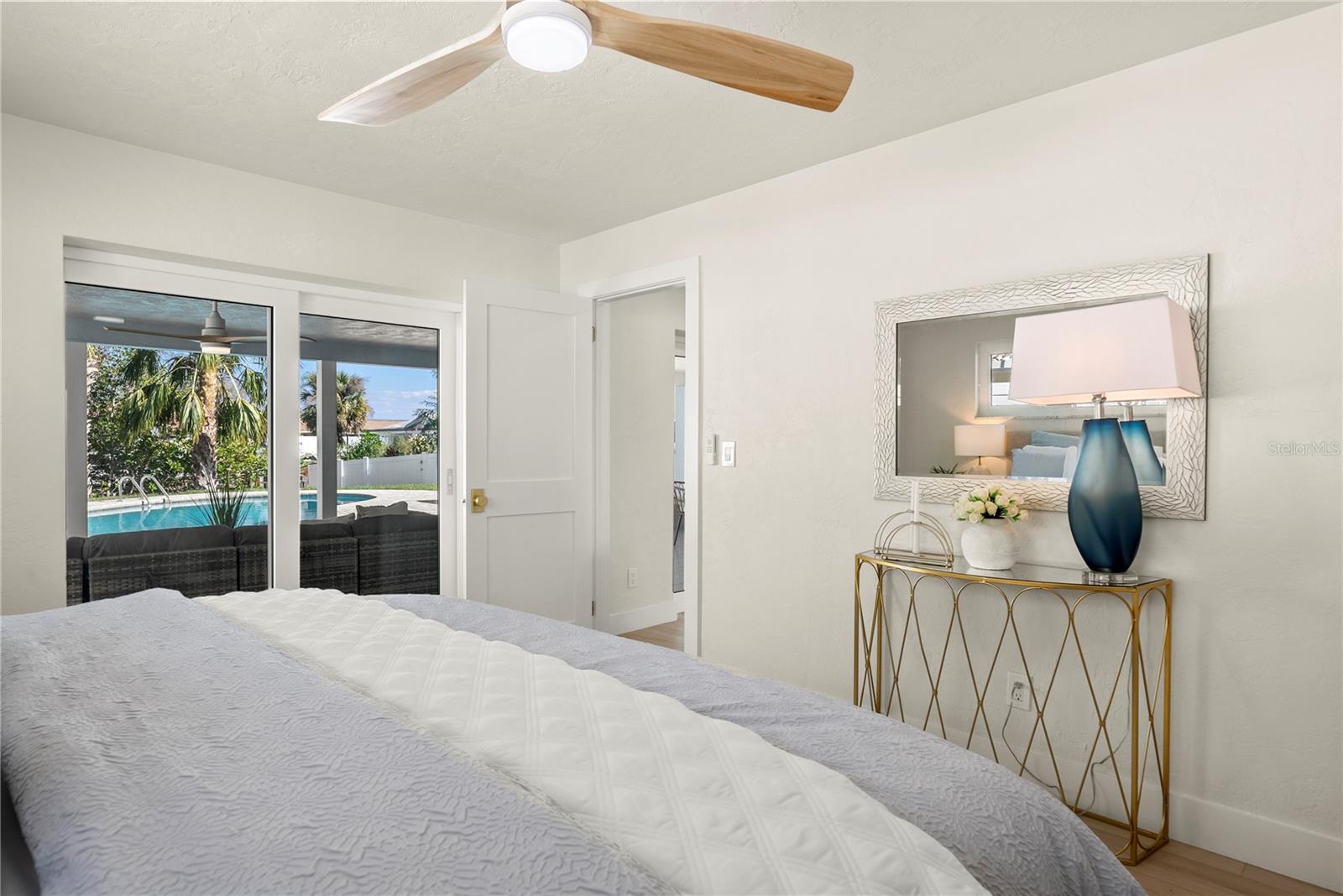 Primary bedroom with a slider to the covered lanai and pool area