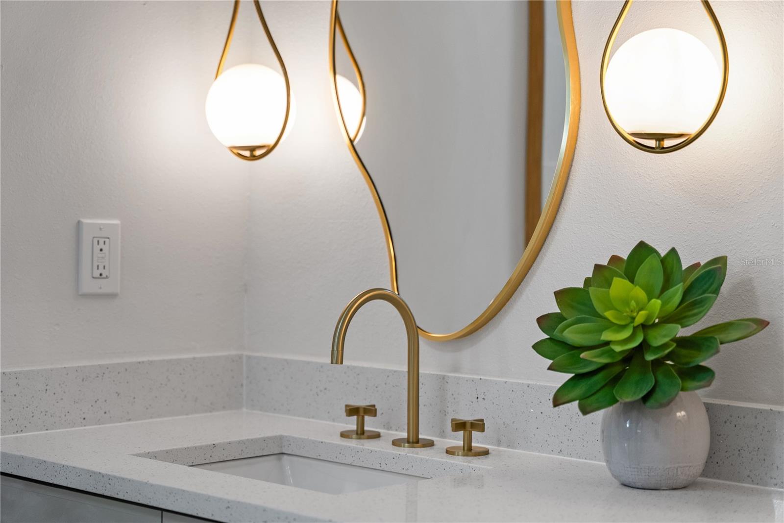 Close up detail of the sink, mirror and light fixtures in the Primary bedroom