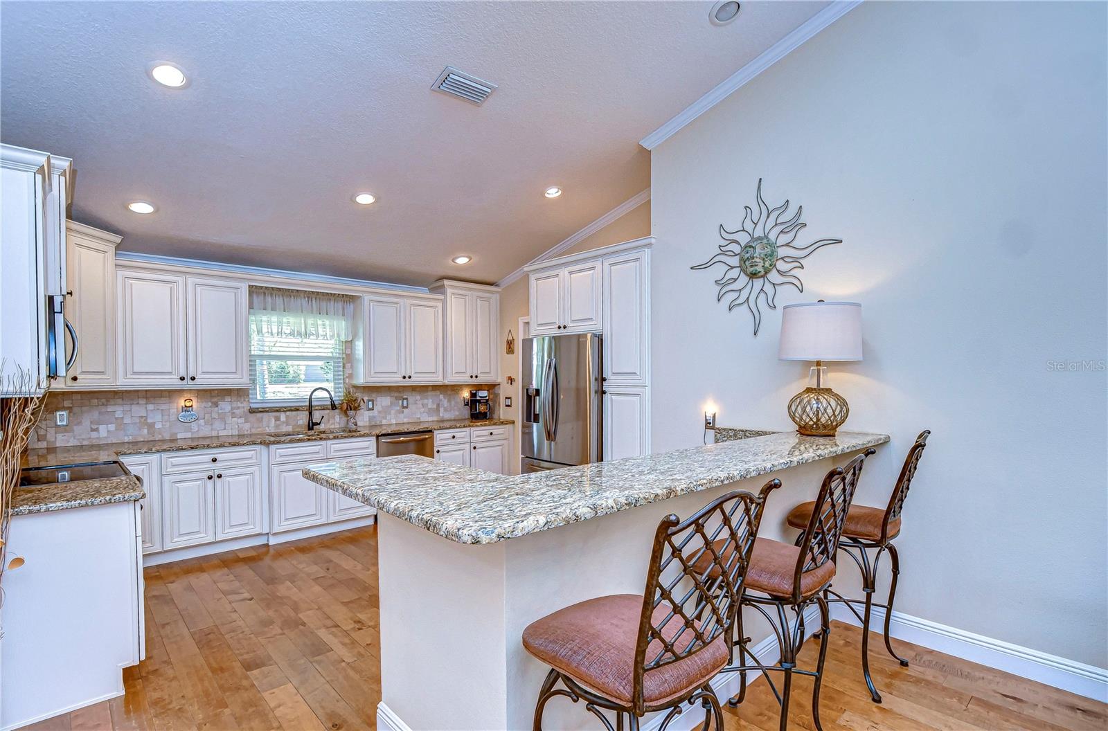 Whisk up gourmet meals in this charming kitchen with gleaming granite countertops, modern stainless steel appliances, and a cozy breakfast bar