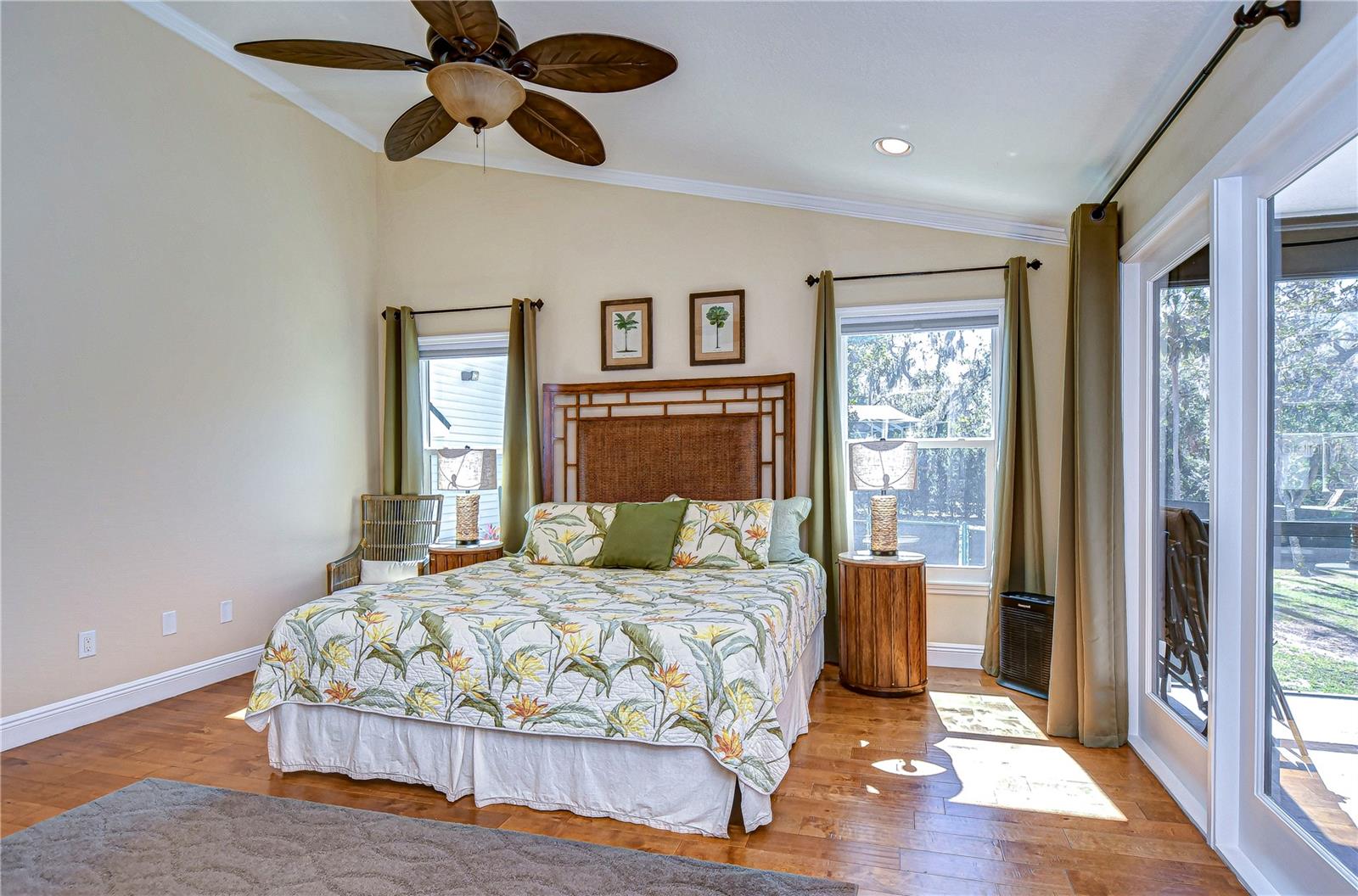 The inviting primary bedroom offers vibrant  natural light, and serene backyard views.