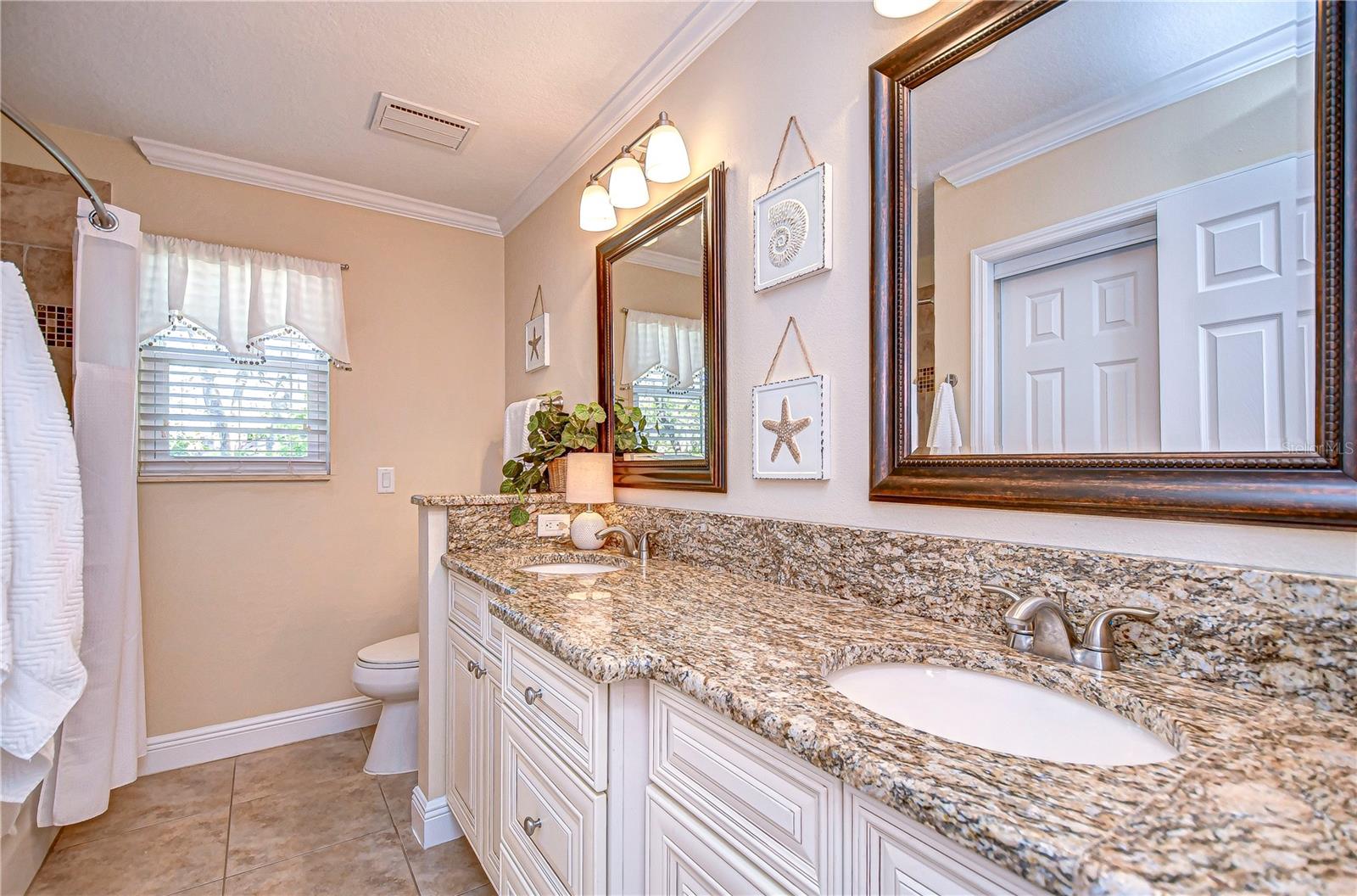 Step into elegance with this beautifully designed second bathroom featuring dual sinks, granite countertops.