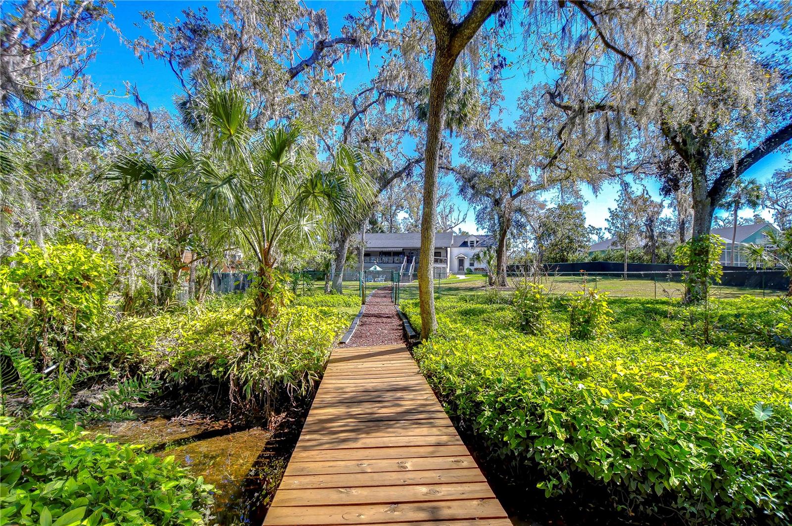 A charming walkway meanders through lush landscaping, leading to a picturesque dock.