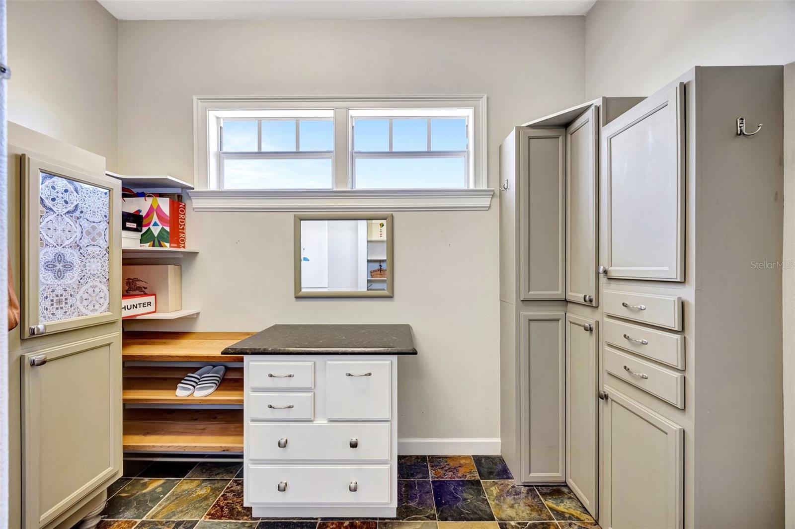 Primary closet features built in shelving and natural light.