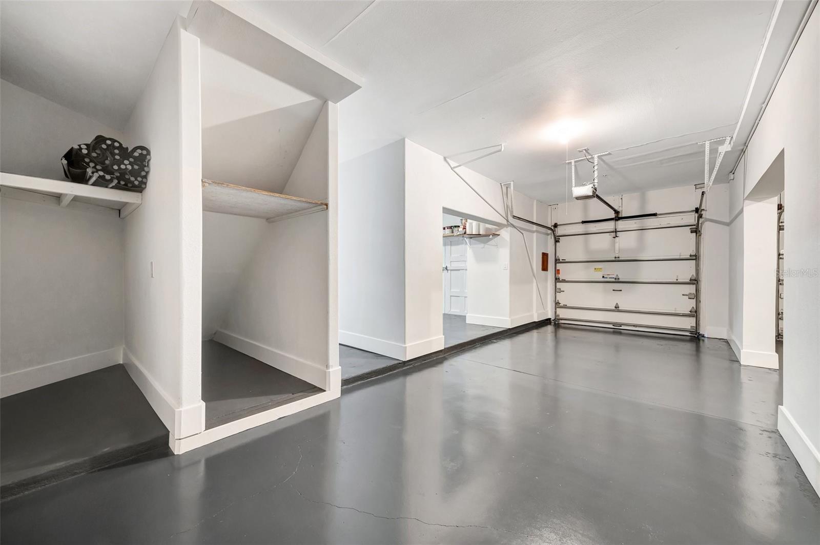 One of two garages, with a utility garage to the left and under stairs storage. All drywall replaced since the storm is multi-resistant drywall with PVC trim.