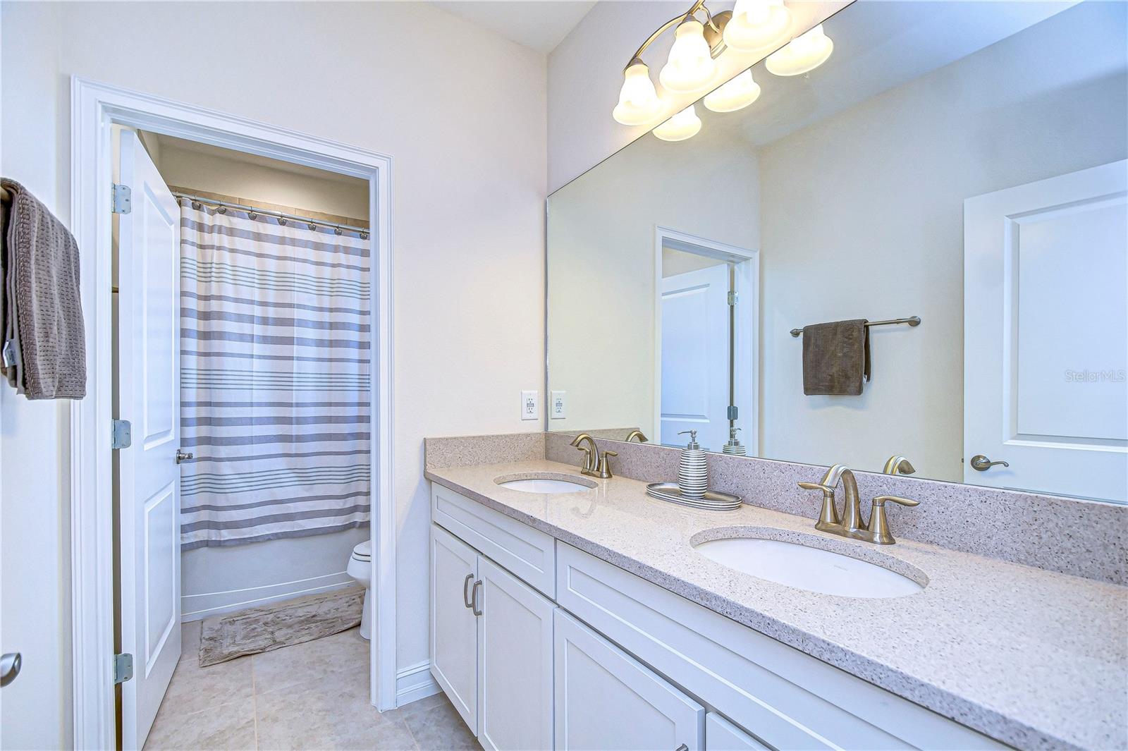 Refresh and unwind in this beautifully designed second bathroom, featuring dual sinks and a large mirror.