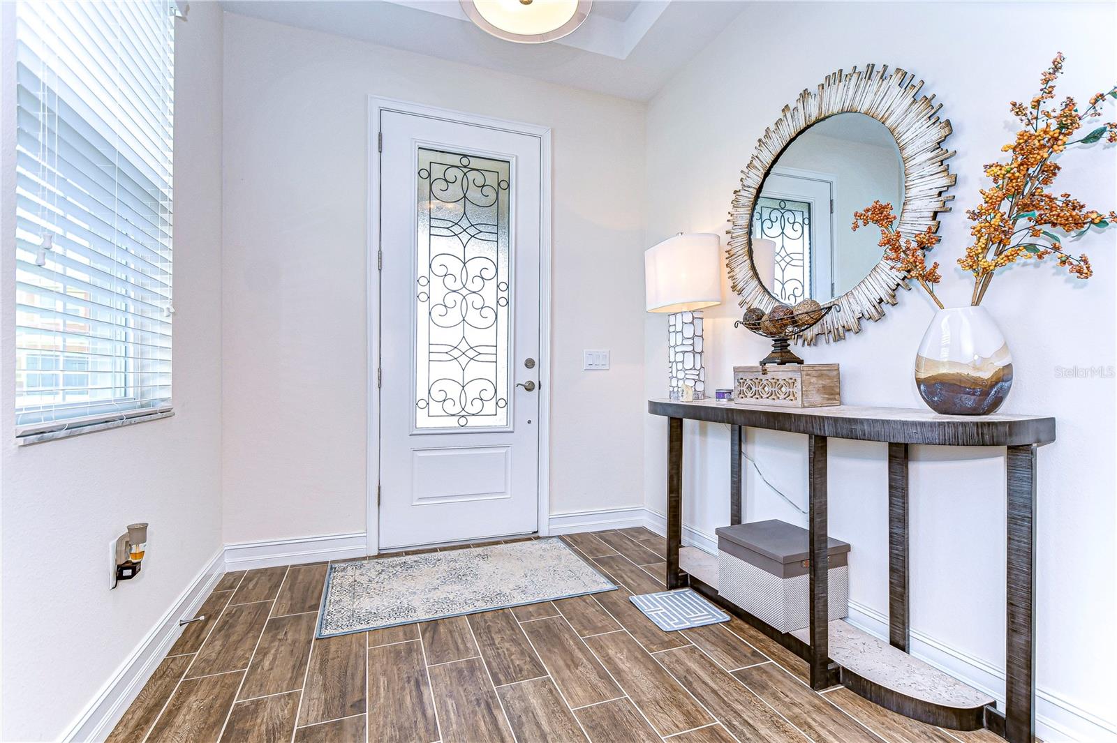 Step into elegance with this beautifully designed entryway, featuring sleek wood-look tile floors