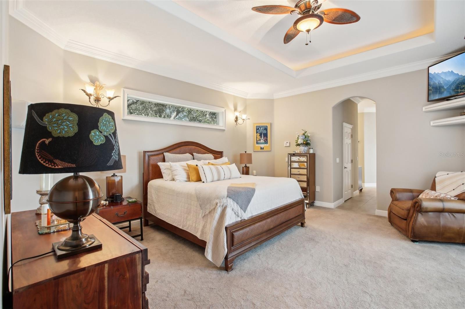 Beautifully designed Primary Bedroom #1 with sitting area, 2 walk-in closets and ensuite bathroom. View to the Lanai and pool area