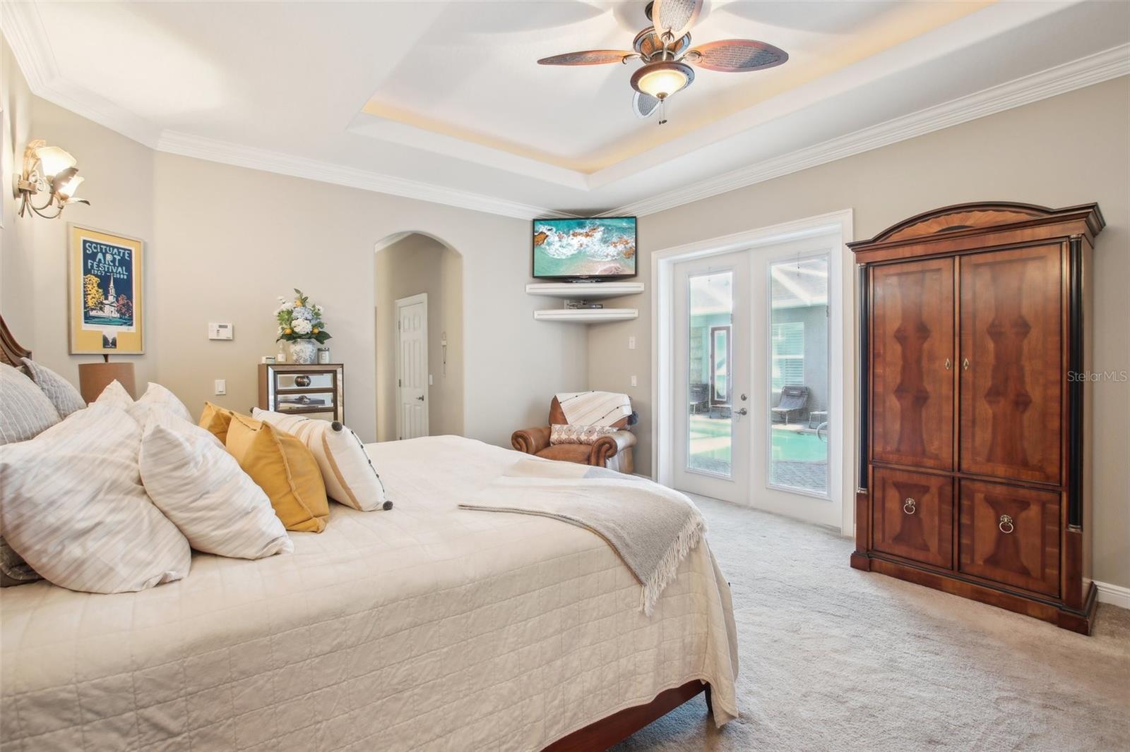 Beautifully designed Primary Bedroom #1 with sitting area, 2 walk-in closets and ensuite bathroom. View to the Lanai and pool area