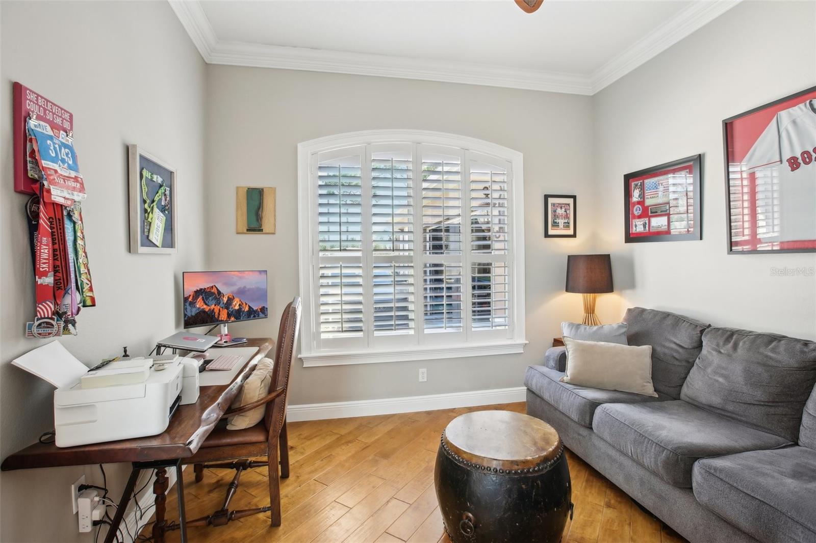 Office/den with hardwood floor and plantation shutters