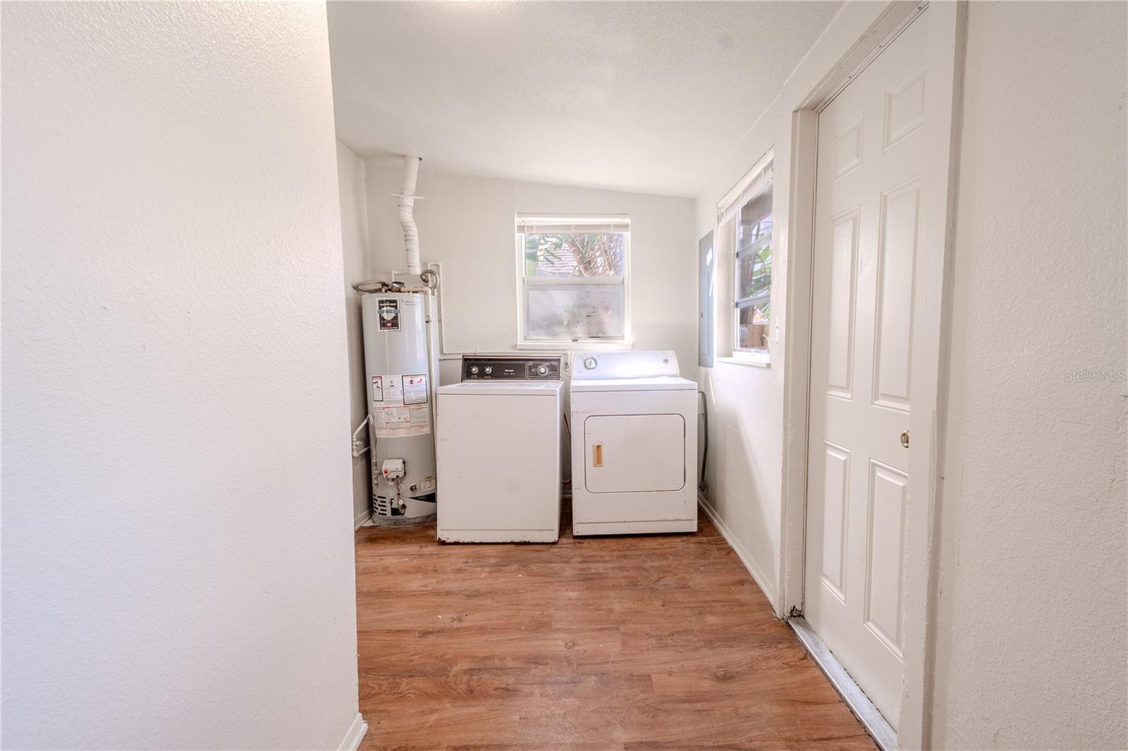 Unit 2 - laundry room with laminate flooring washer and dryer.