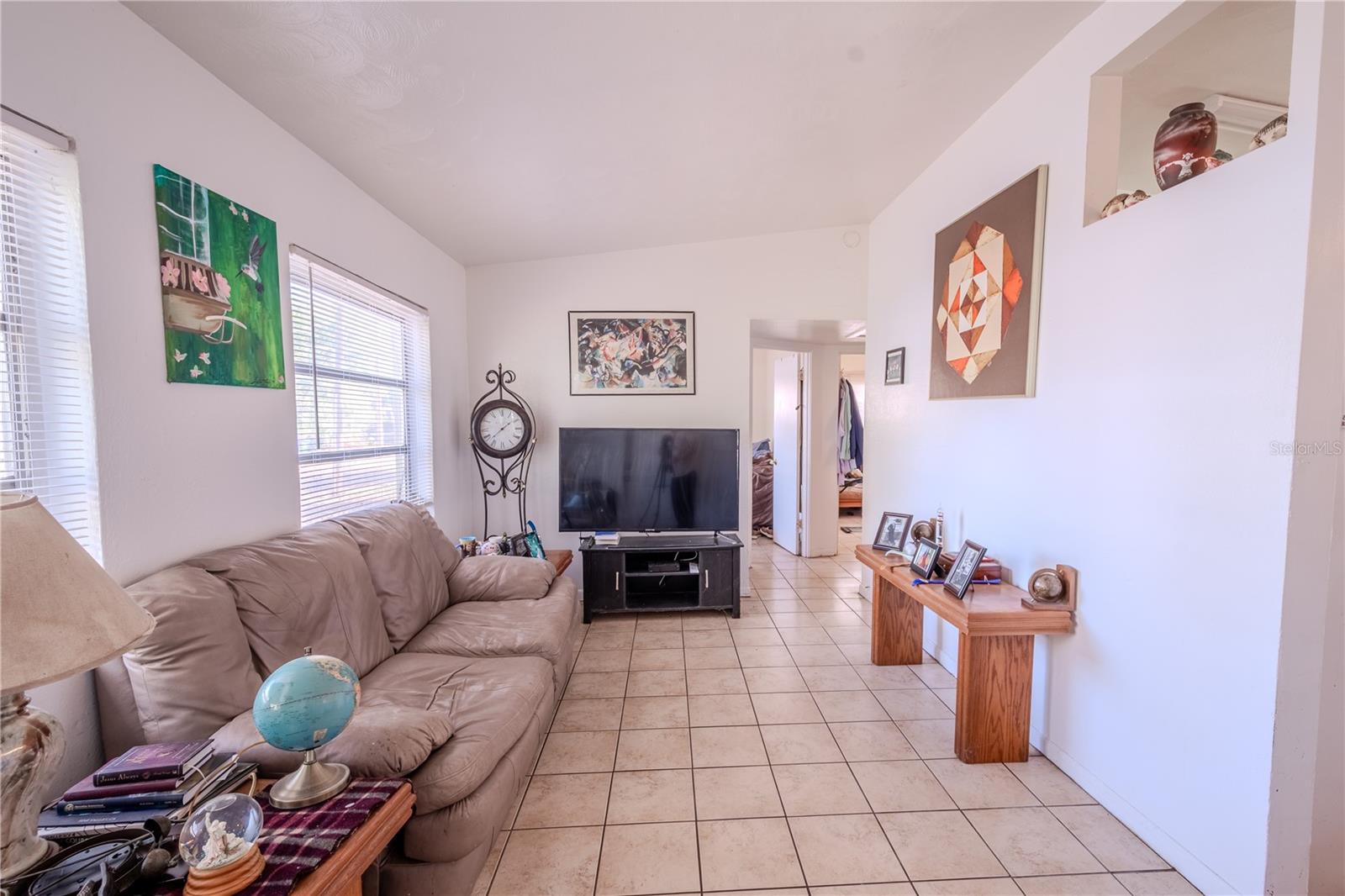 Unit 1 - Living room has a tile floor and 2 large windows.