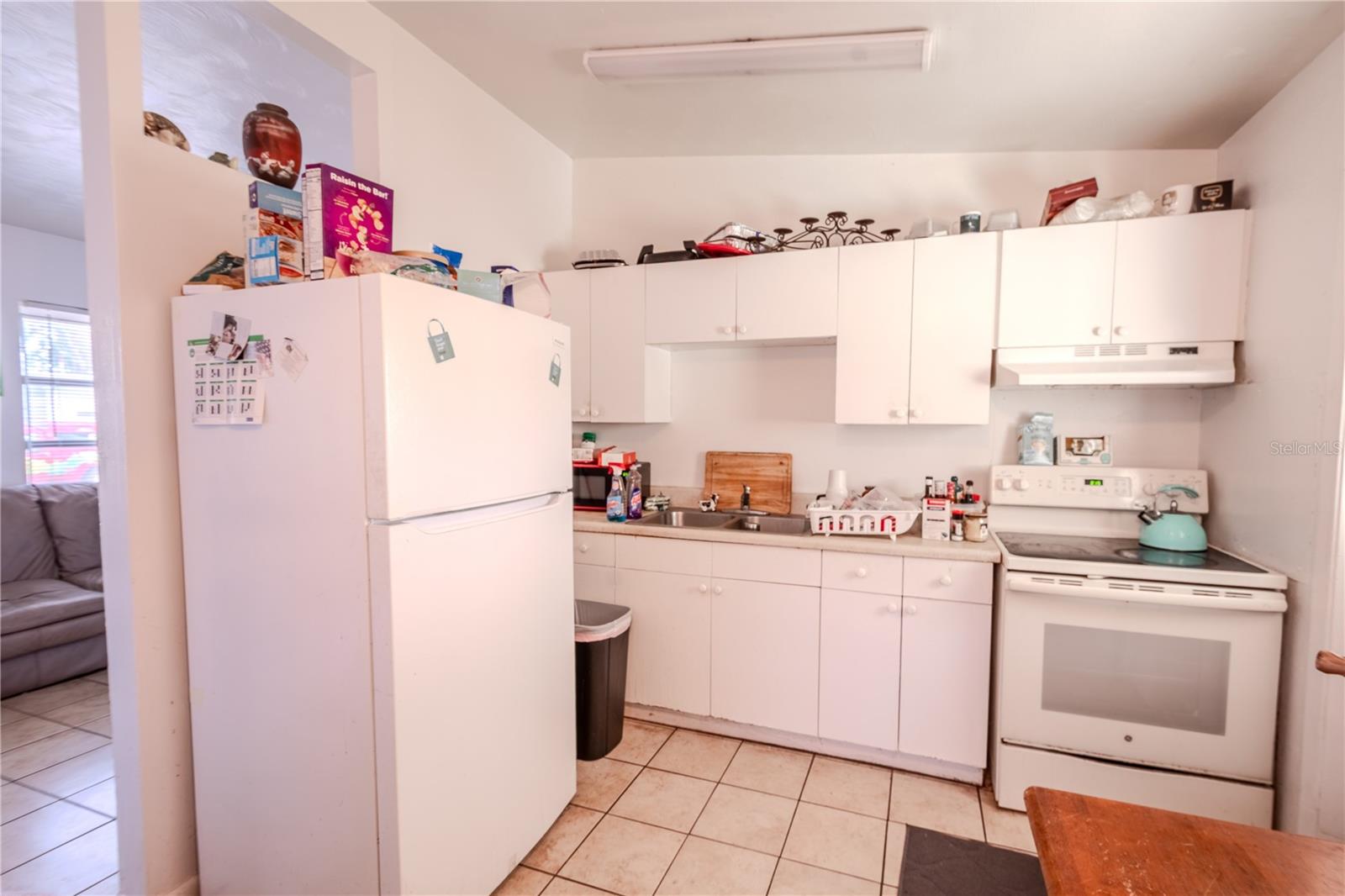 Unit 1 - Kitchen has a tile floor. double basin sink, refrigerator and range.