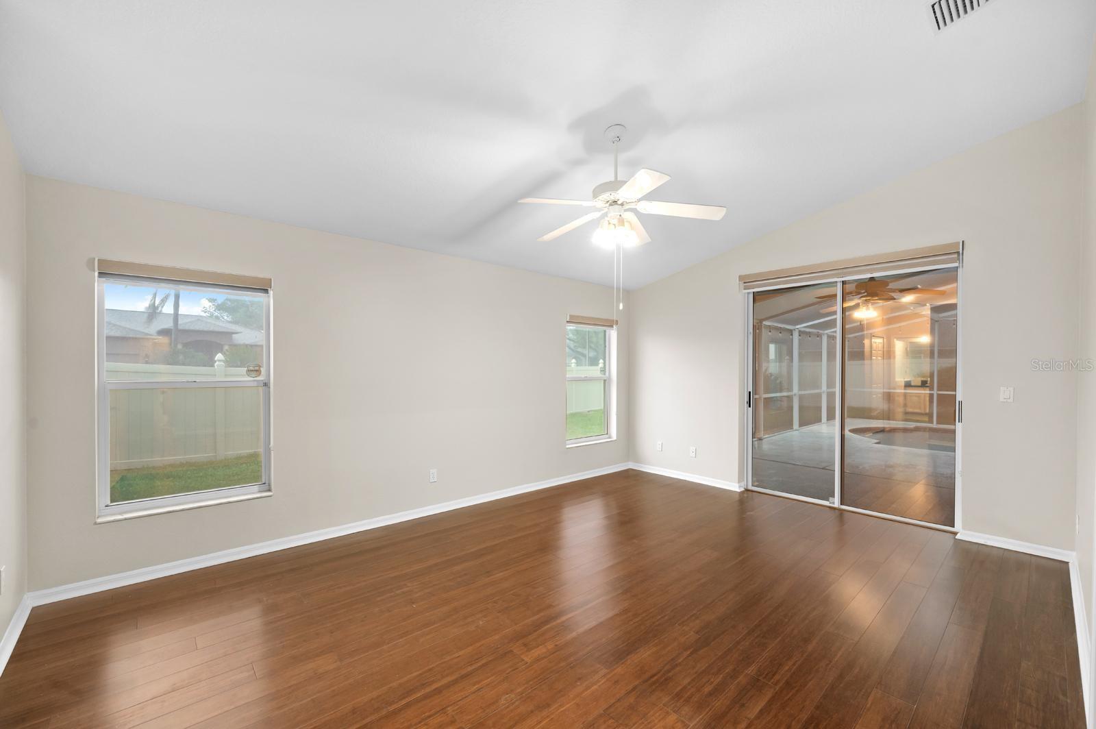 The Primary bedroom has bamboo floors, a newer ceiling fan, and a slider with a window shade.