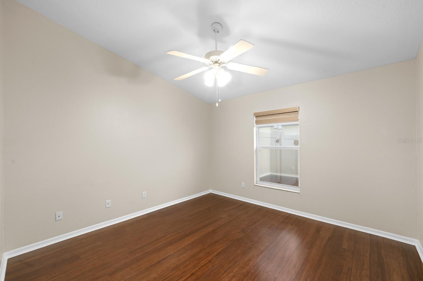 Bedroom 3 has a newer lighted ceiling fan, bamboo wood flooring, and a window shade.