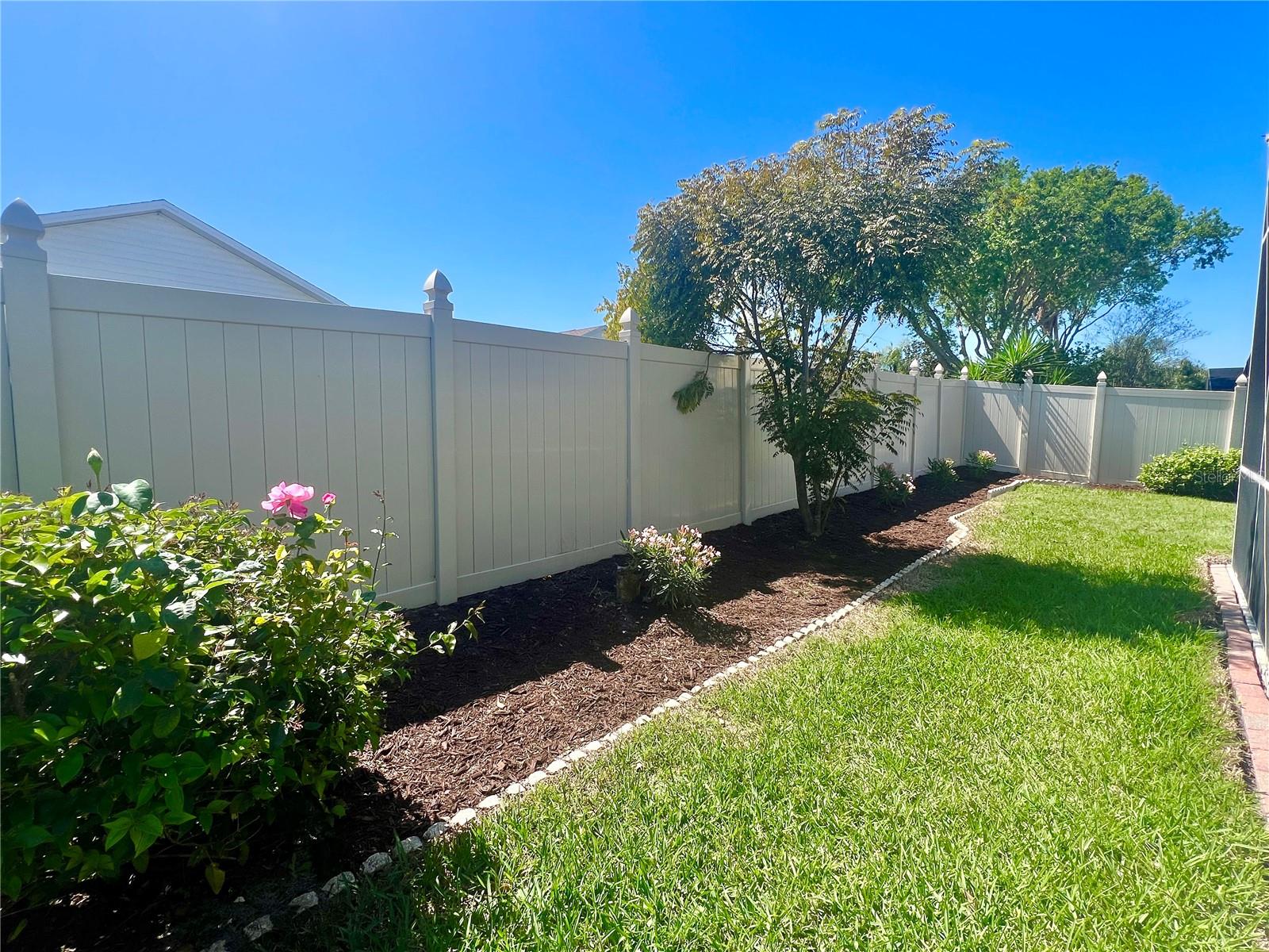 New oleander flowers planted and fresh mulch and a 2018 installed vinyl fence.