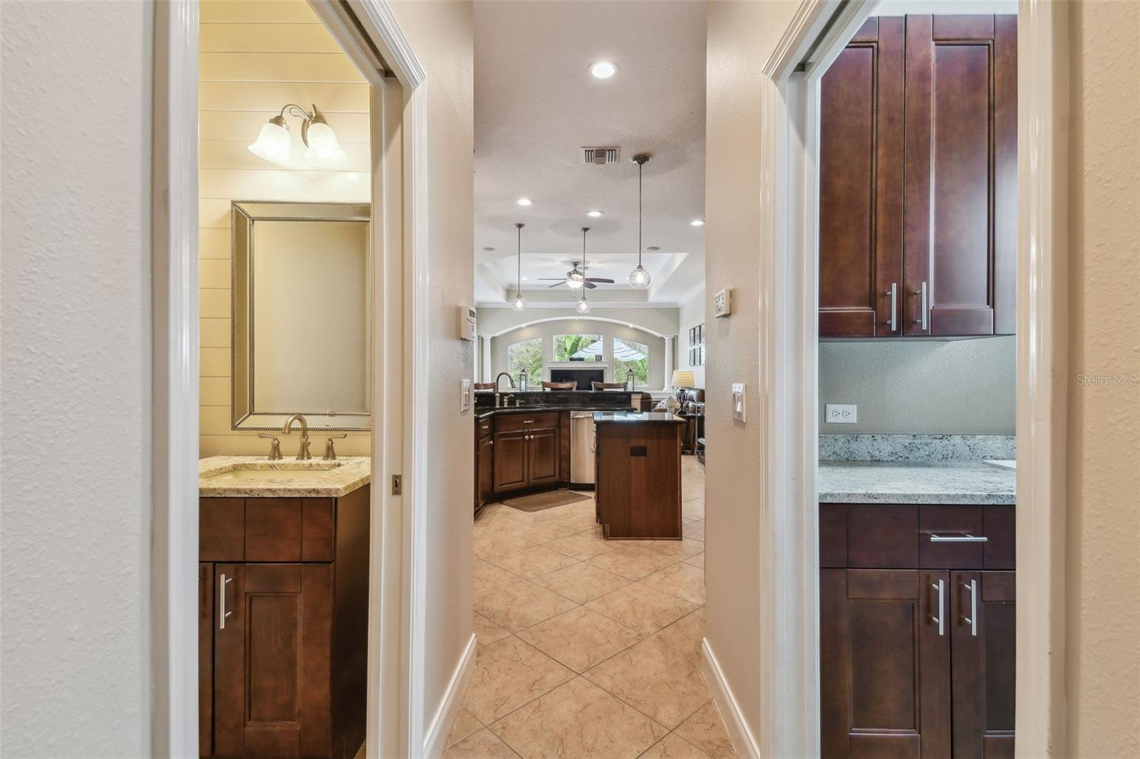 Hallway from 2-car garage w/laundry on right and 1/2 bath on left