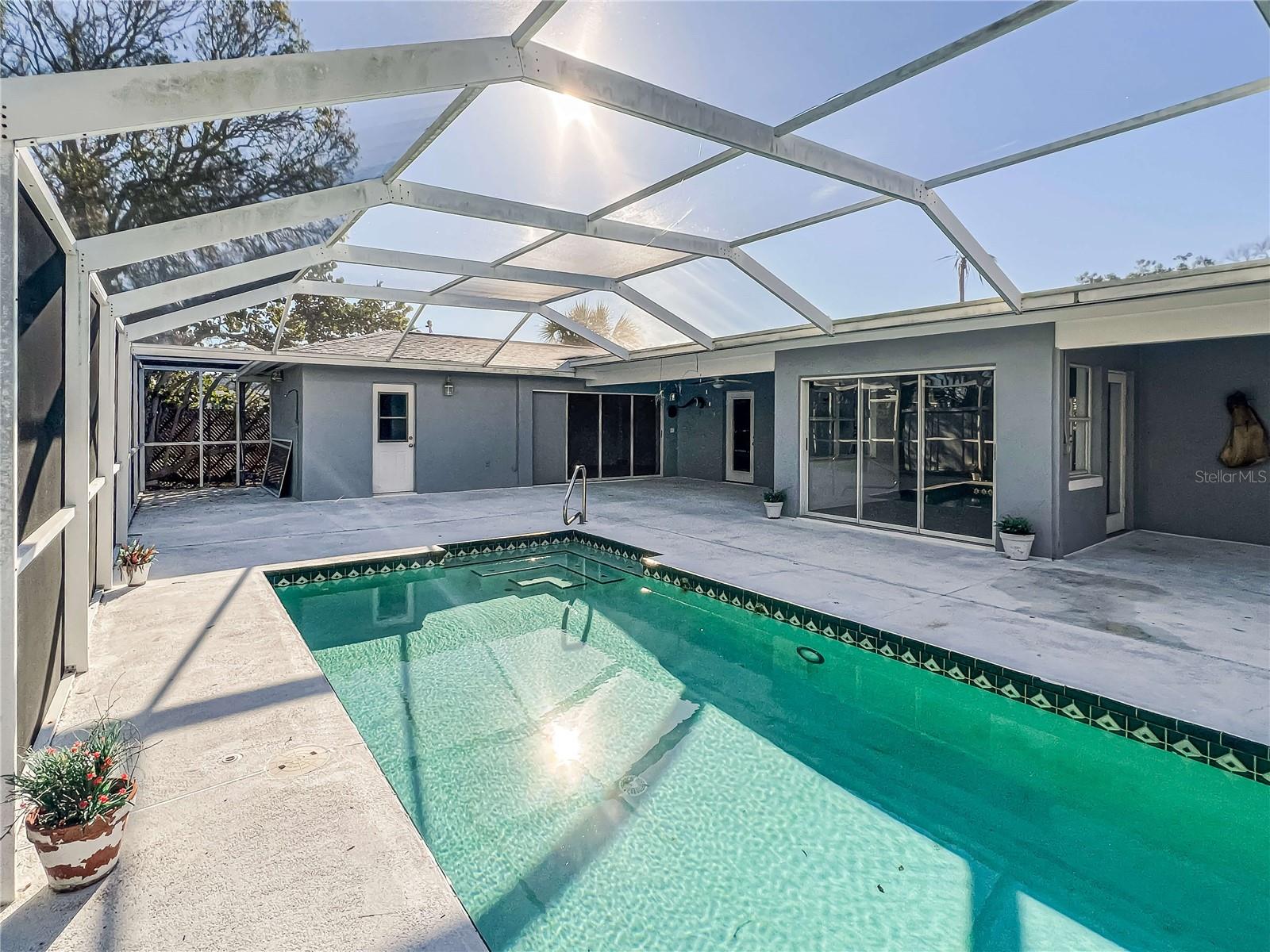 Back of house with screened lanai and pool