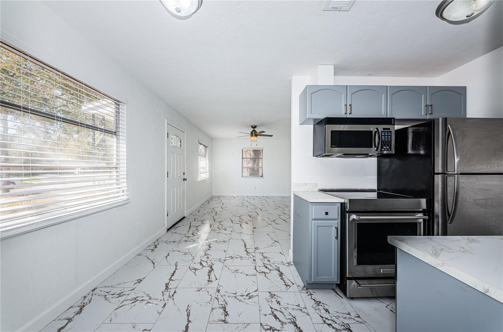 Kitchen with eat in area and living room.  Front door on the left