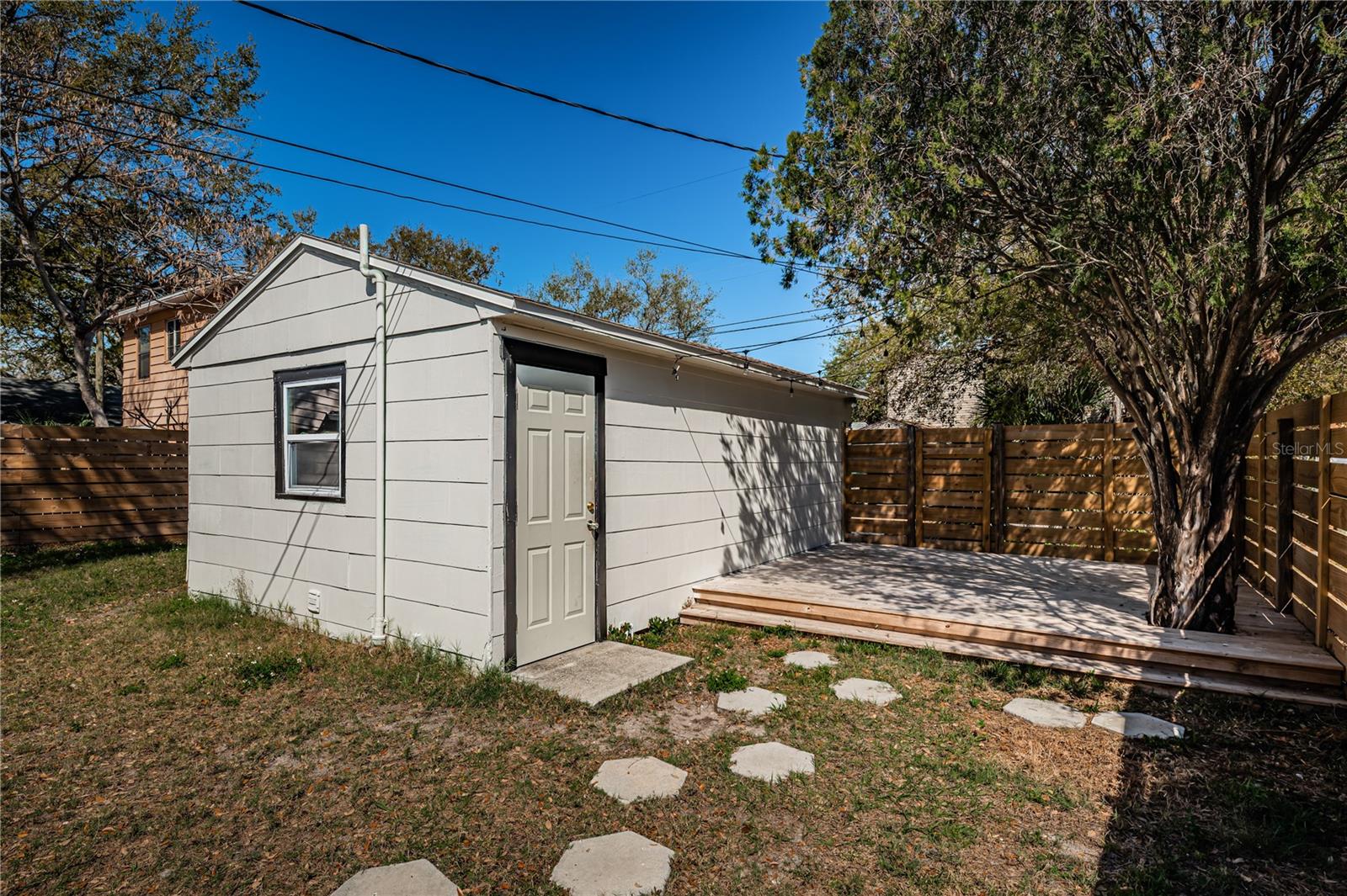 Looking towards the backyard from the house's backdoor.  Showing detached garage and deck.