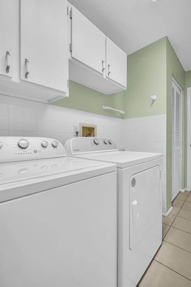 Convient inside laundry room with cabinets...