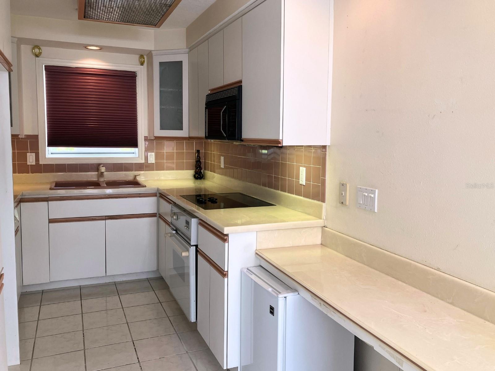Kitchen has a built in desk and small fridge