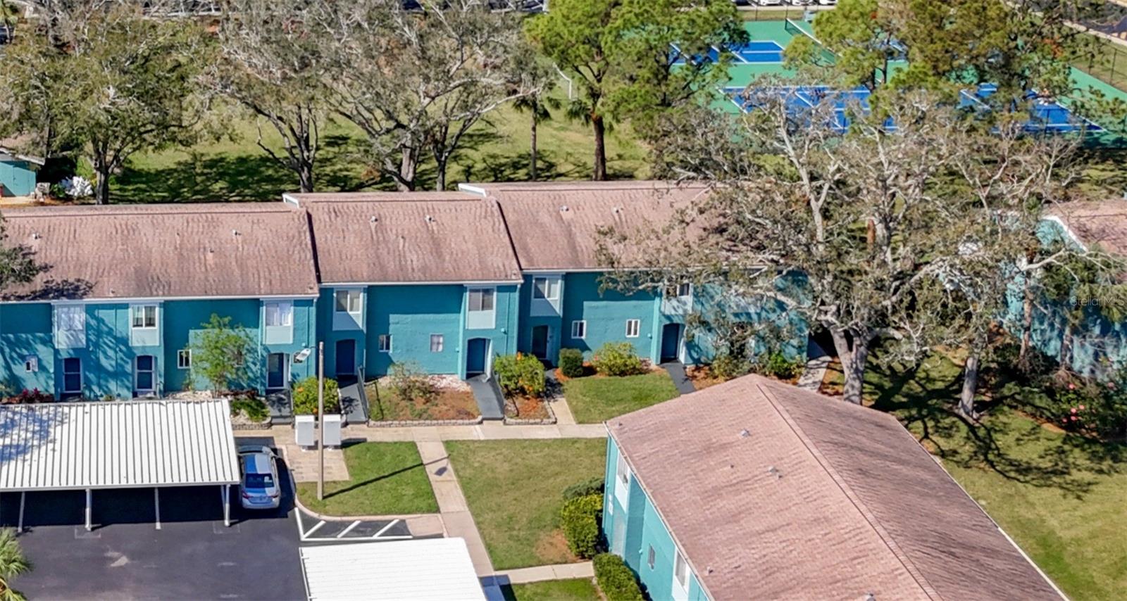 Front of building 9 showing the park and courts on the backside. Your door is the first one far left in the photo. Your mailbox is shown here in front of the building as the light colored boxes next to the vehicle.