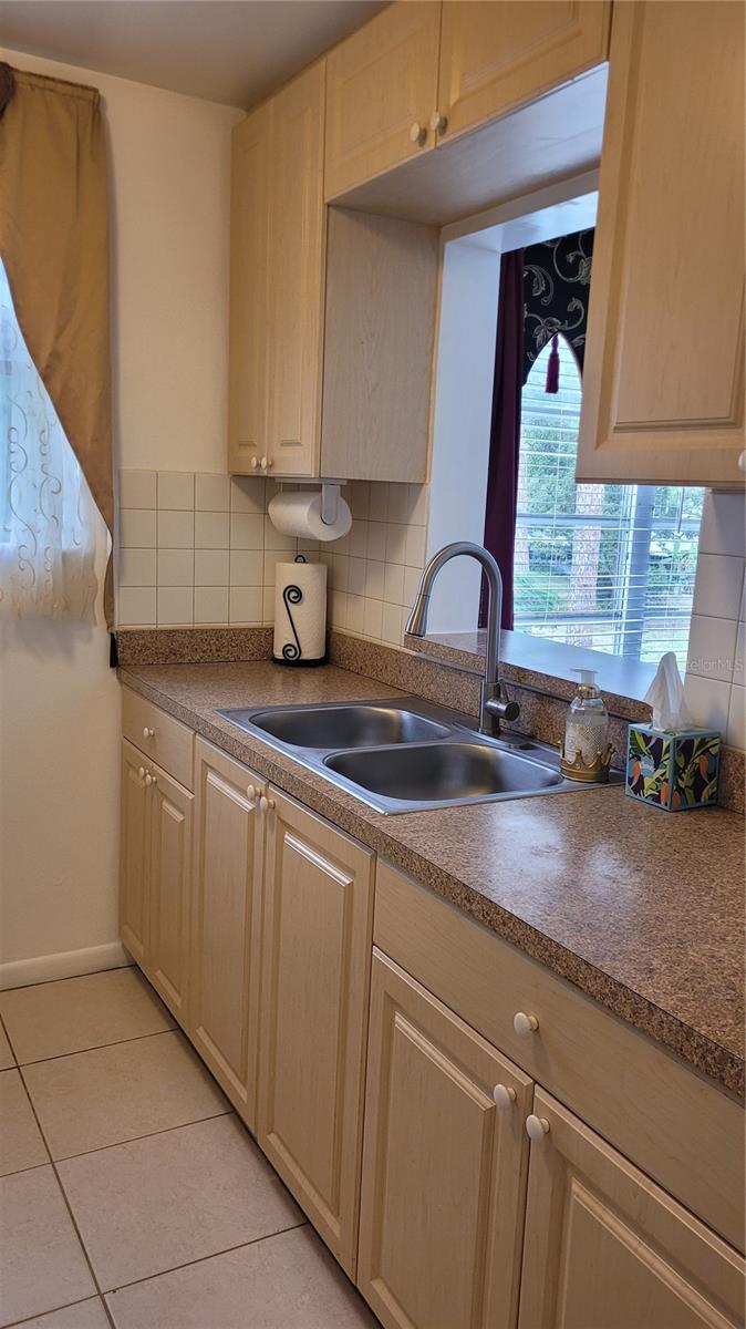 Updated kitchen cabinets with stainless steel sink and newer faucet