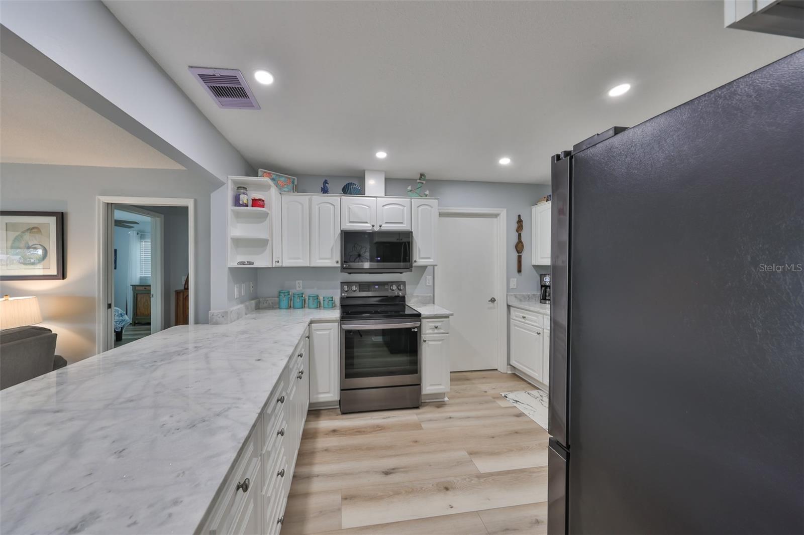 A large breakfast bar and counter with new recessed lighting.