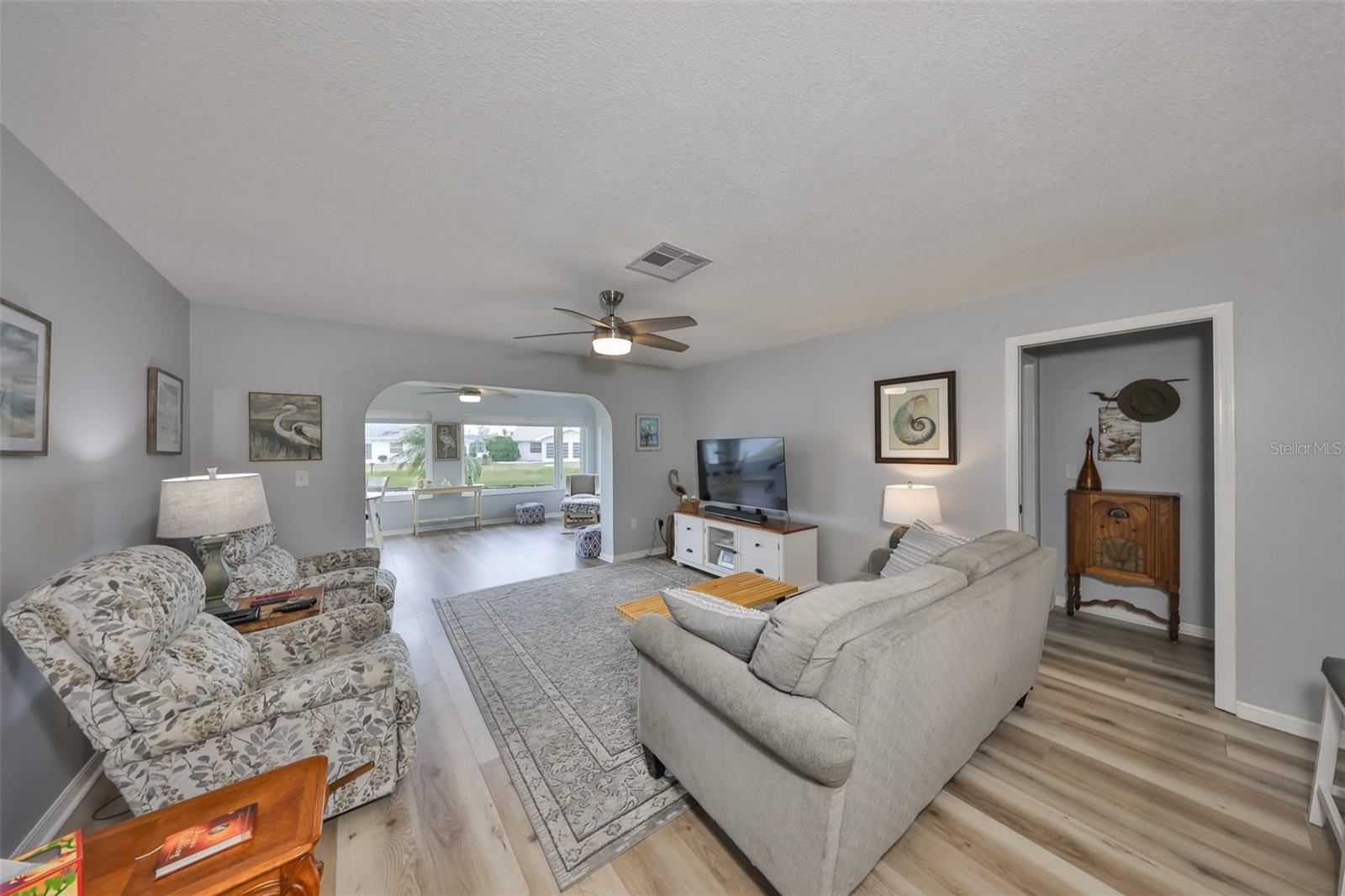 Beautiful flooring, new lighting, and removal of the popcorn ceiling really makes this room.  Notice that the flooring is all one level and one of the master suites is to the right of the room and one is to the left.