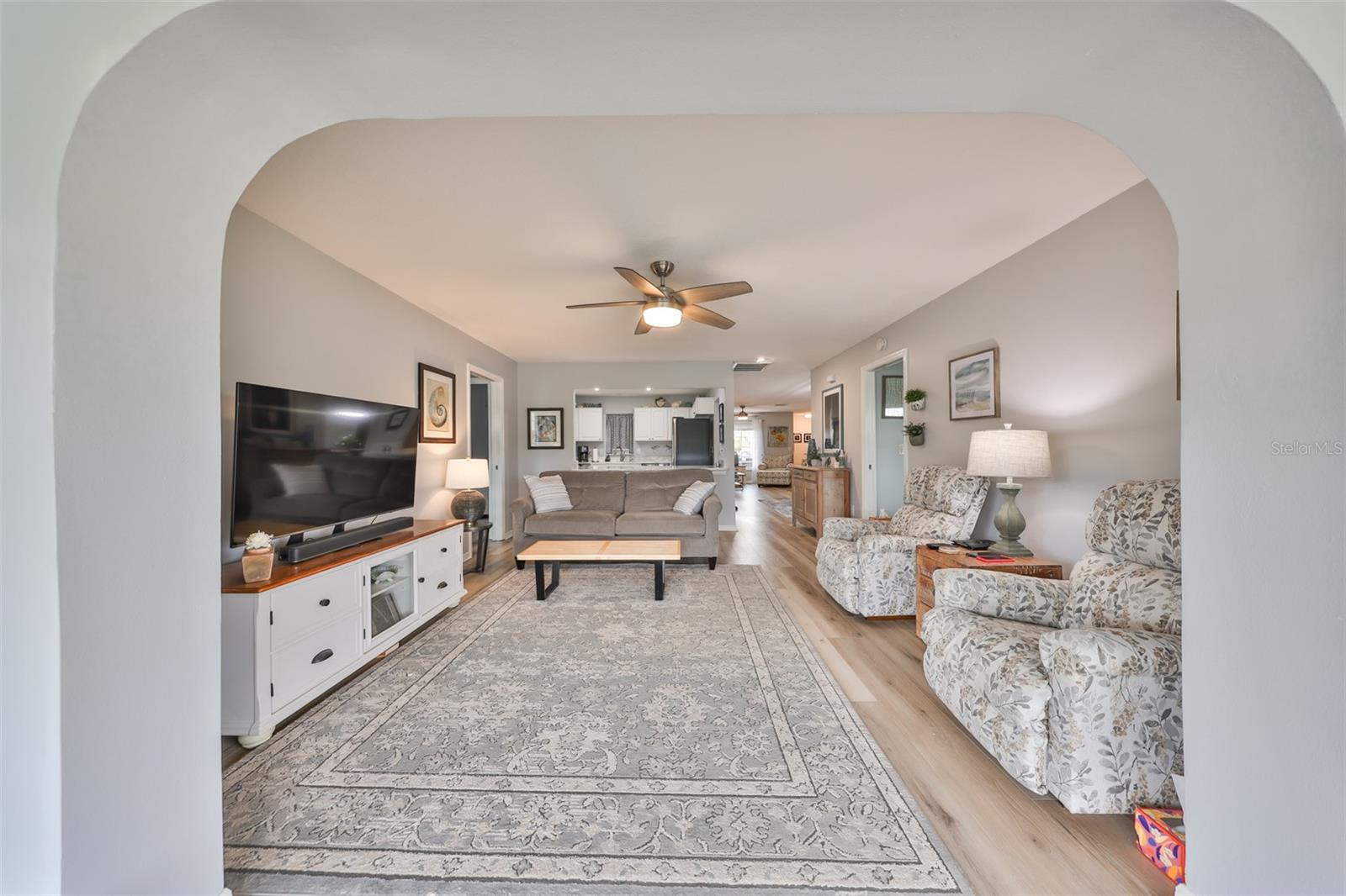 A view from the Florida room into the family room with the kitchen in the far back.