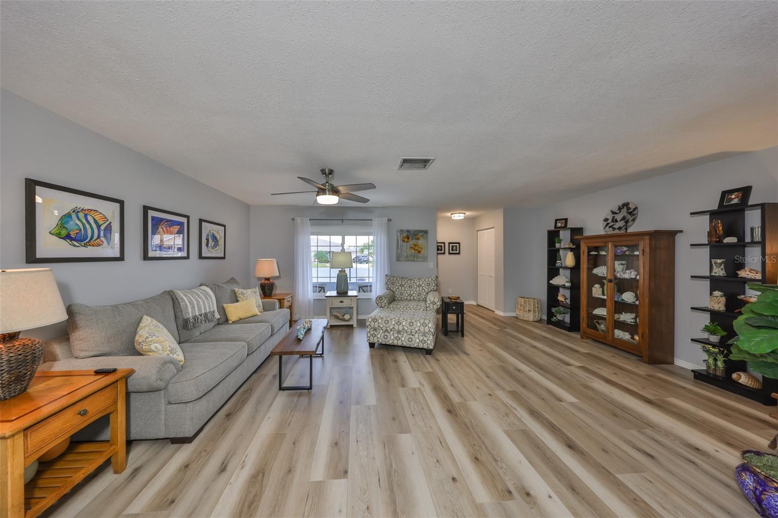 A view of the front entrance, notice the oversized window, beautiful authentic wood laminate flooring and soft neutral paint tones.