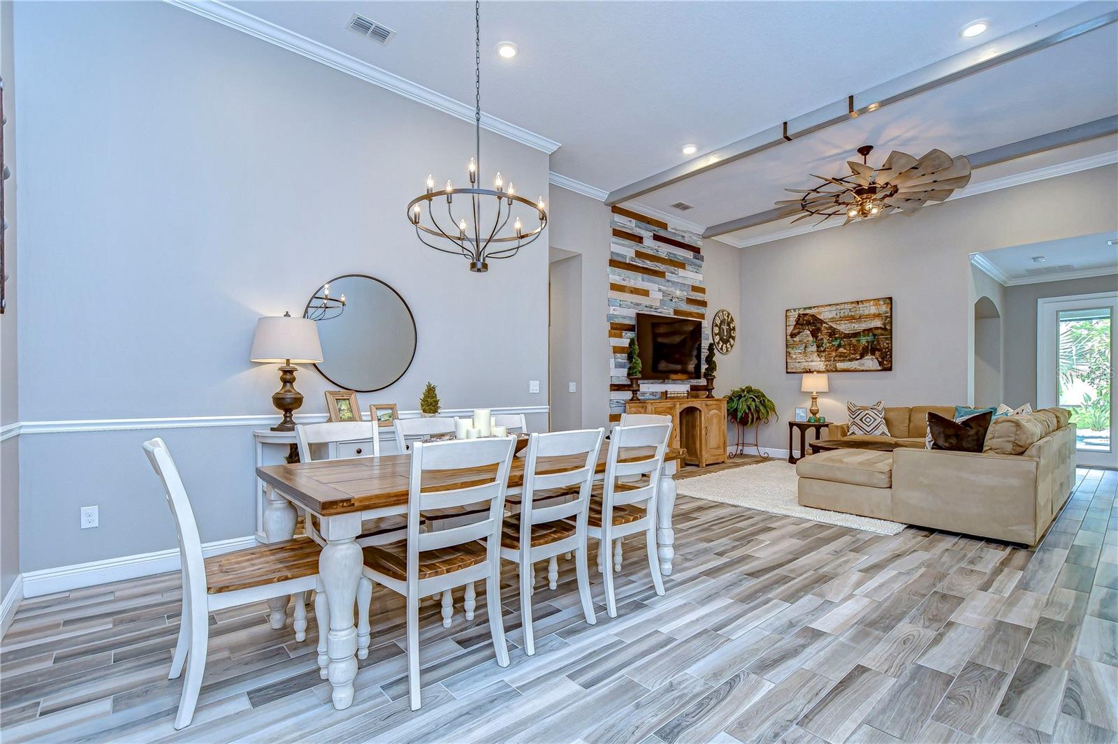 Perfect for entertaining, the chic dining area seamlessly flows into a warm living room with a striking accent wall.