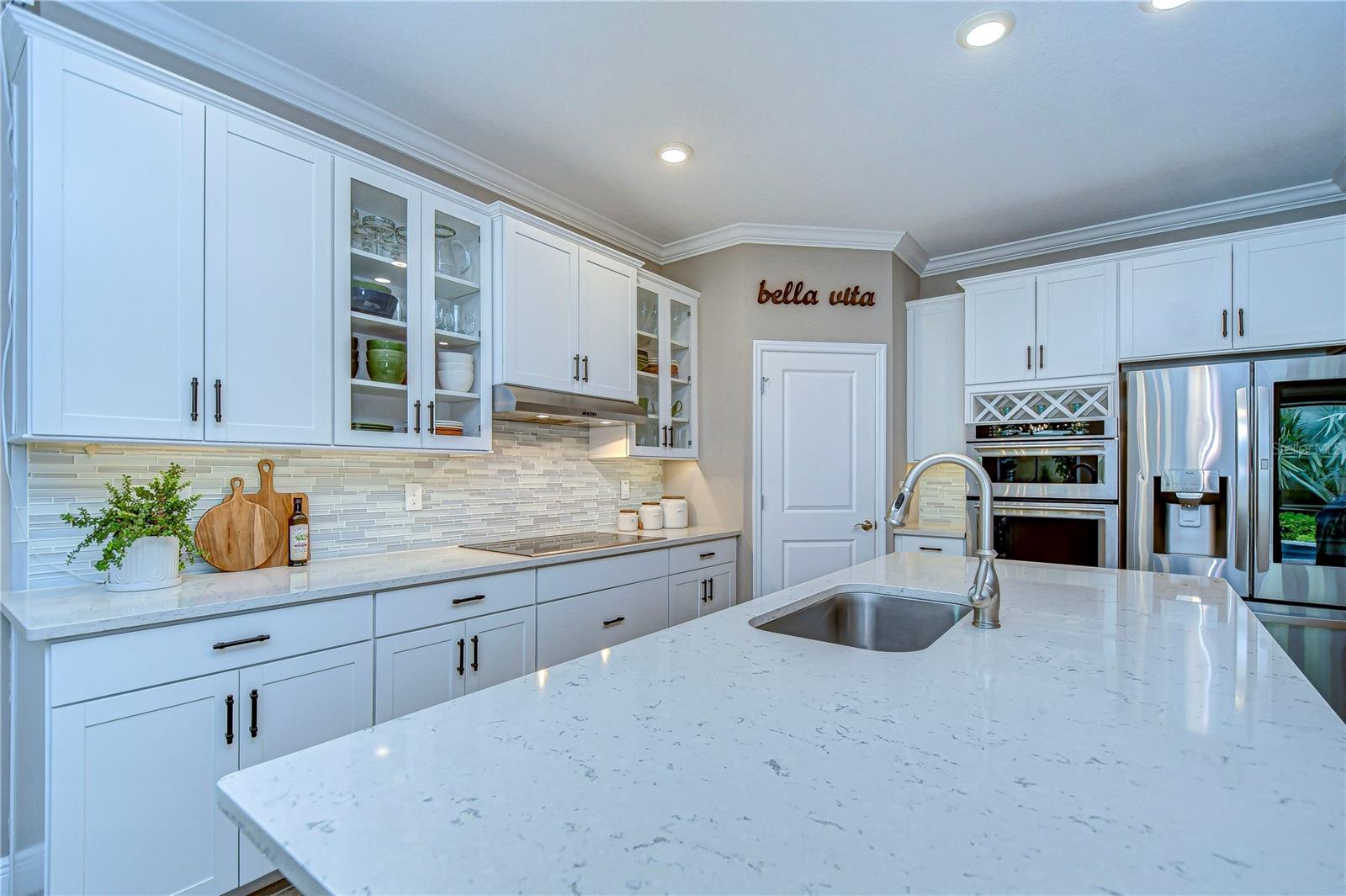 Sleek quartz countertops and custom cabinetry invite you to unleash your culinary creativity.