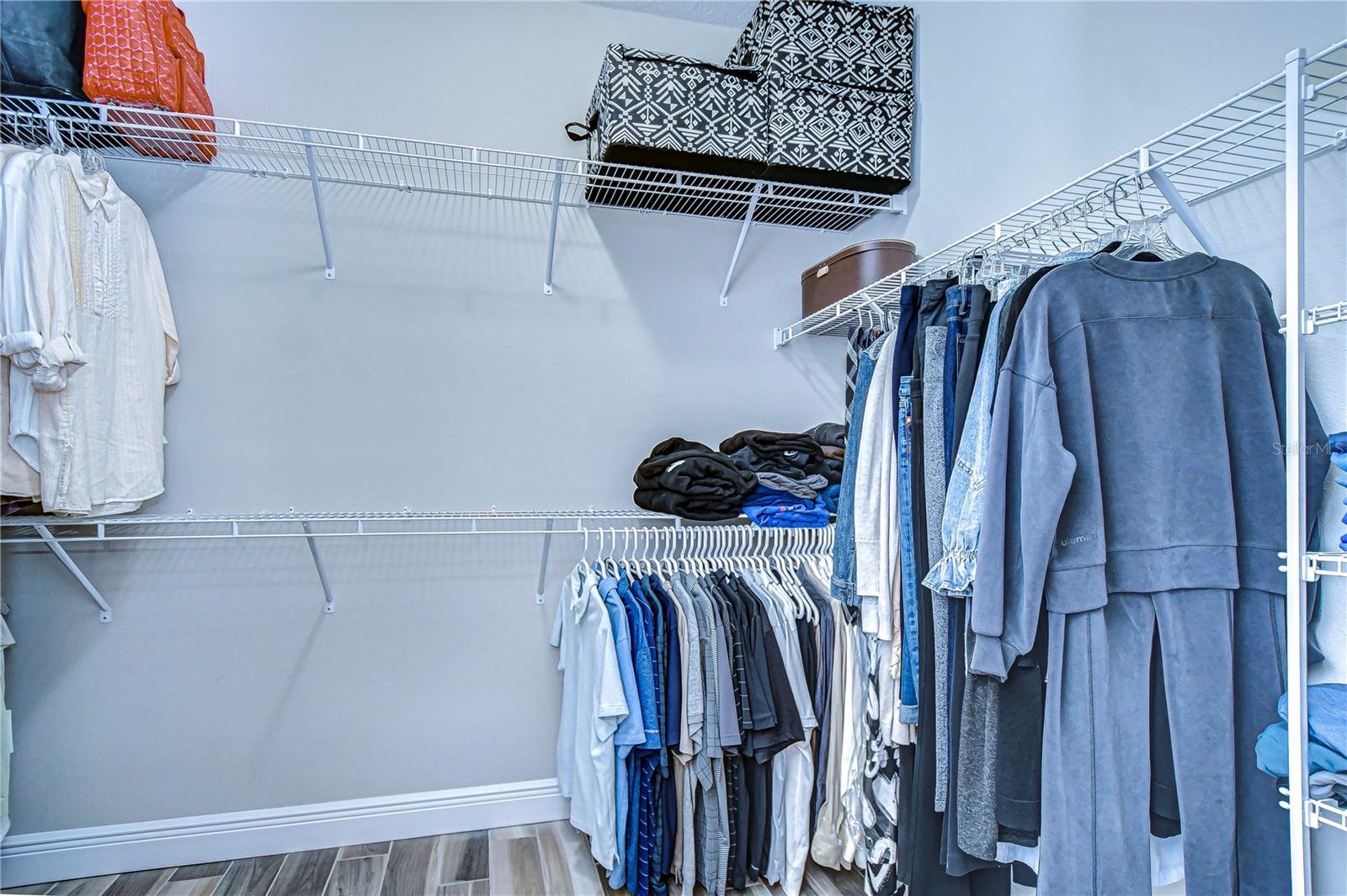 This spacious primary closet offers ample space for all your prized possessions.