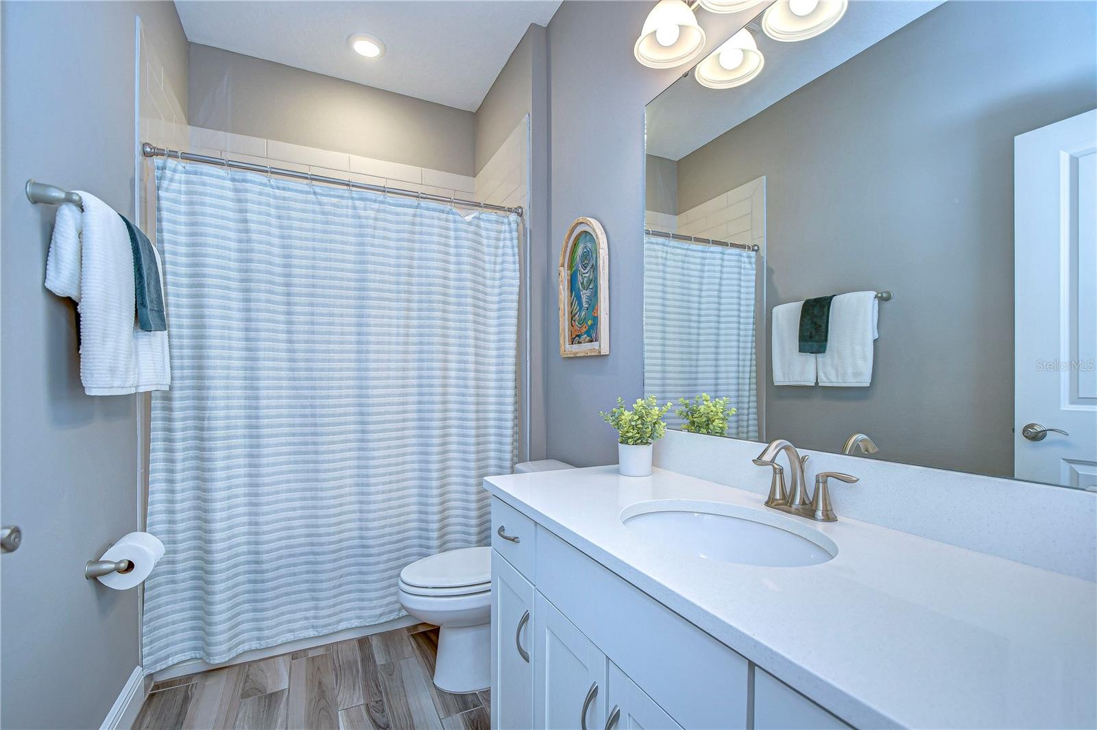 Enjoy the tranquility of this fresh, bright second bathroom with sleek fixtures.