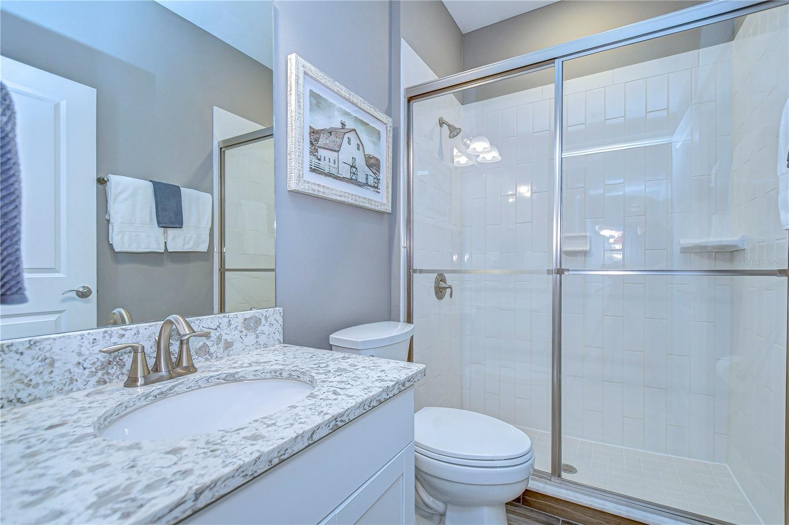 leek fixtures, a spacious shower, and a charming vanity make daily routines feel like a spa retreat in this third bathroom!