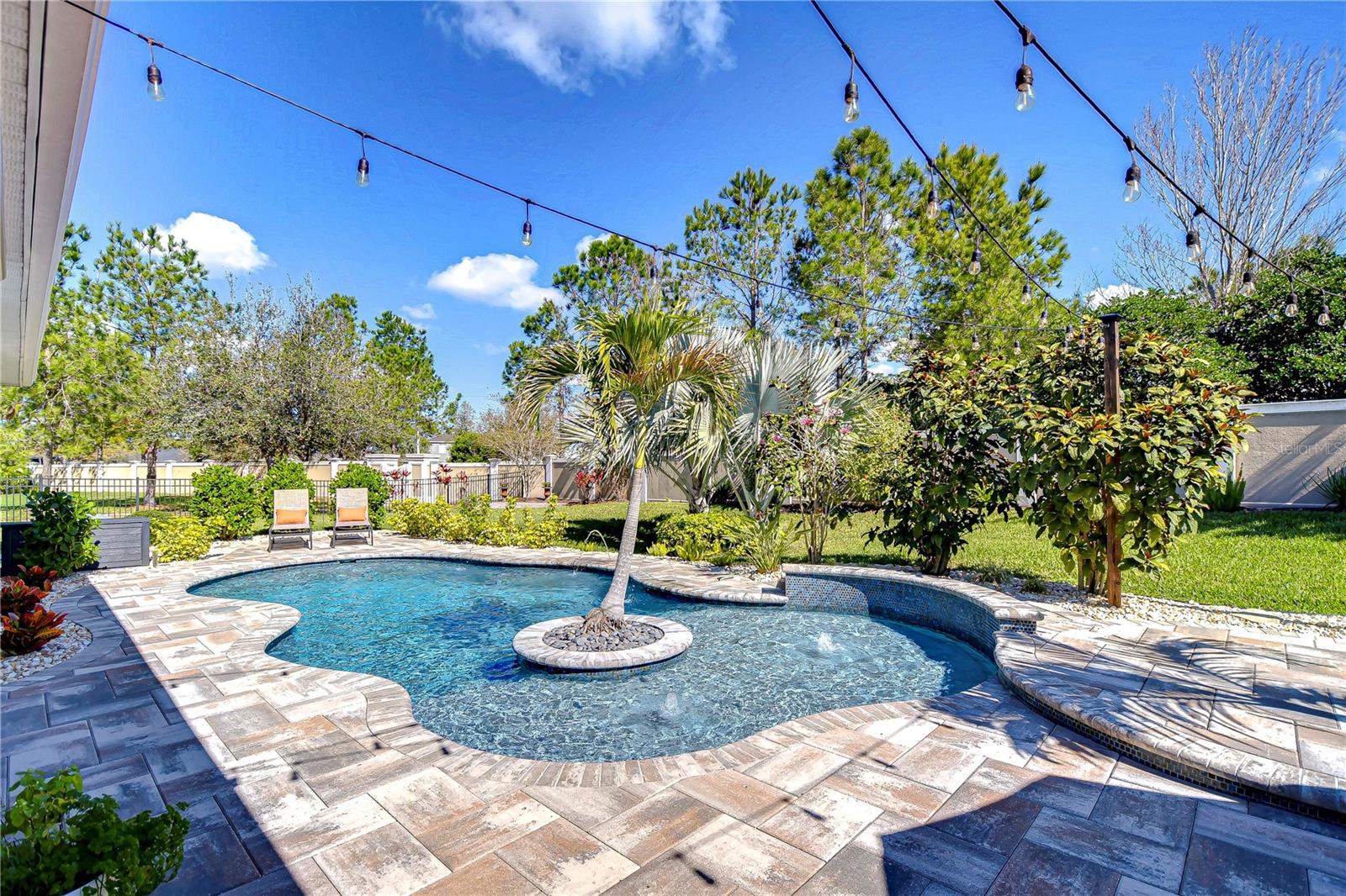 Dive into paradise with this exquisite backyard oasis, where your personal palm tree sways in the middle of your  shimmering, sun-dappled pool.