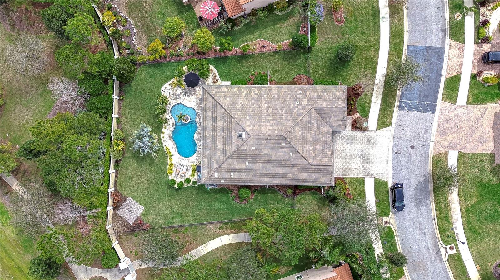 his aerial view showcases a stunning pool and lush landscaping, perfect for sun-soaked relaxation or lively gatherings.