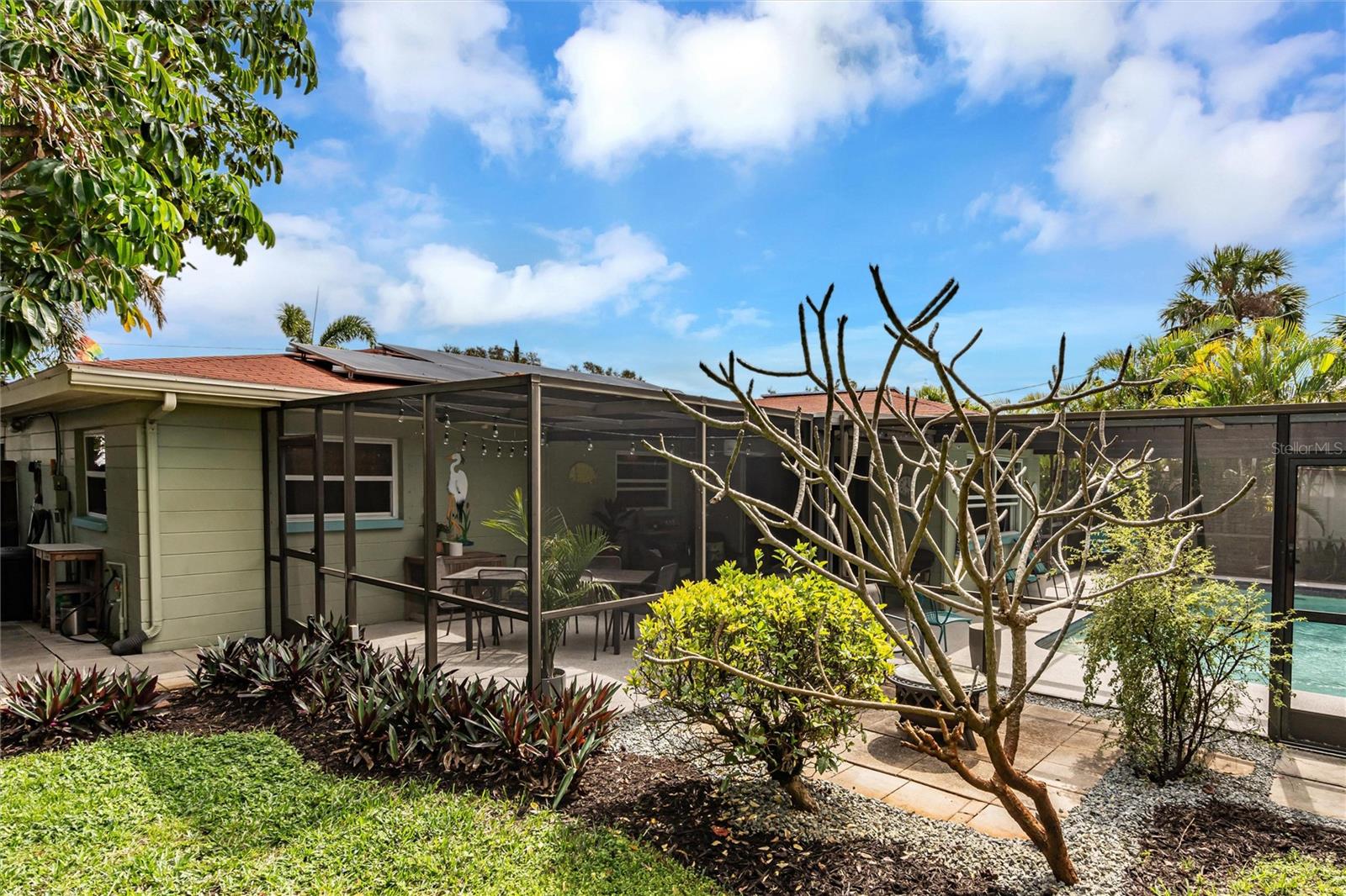 Lush tropical landscaping outside screened pool area