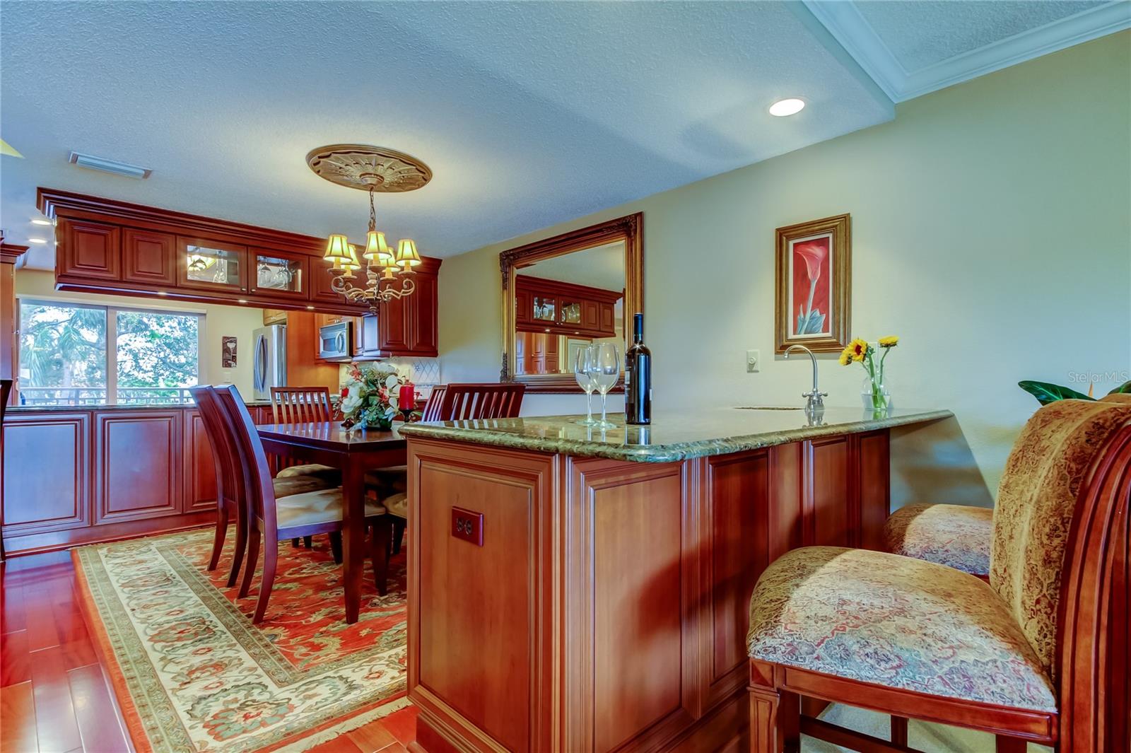 A beautifully crafted dining area and kitchen, and sophisticated breakfast bar, and warm ambient lighting.