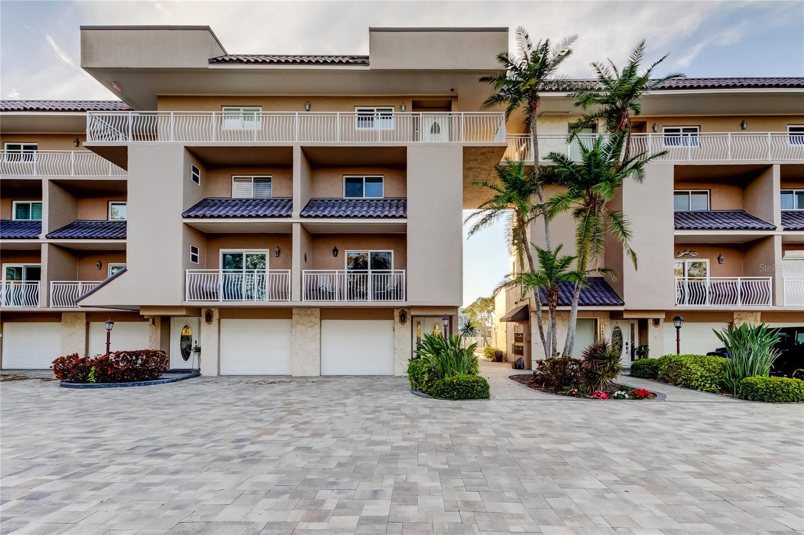 Front view of Unit T-7, featuring an attached garage and a beautifully paved parking lot. A perfect blend of convenience and coastal elegance in this sought-after community.