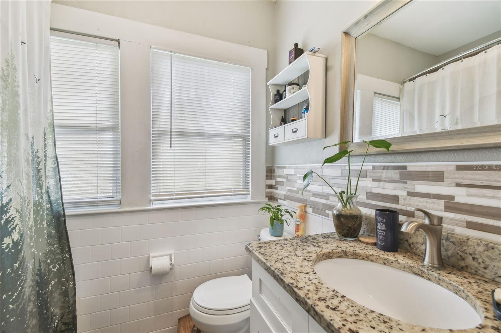 Main Bath with Tiled Shower/Tub and Granite Vanity Countertop